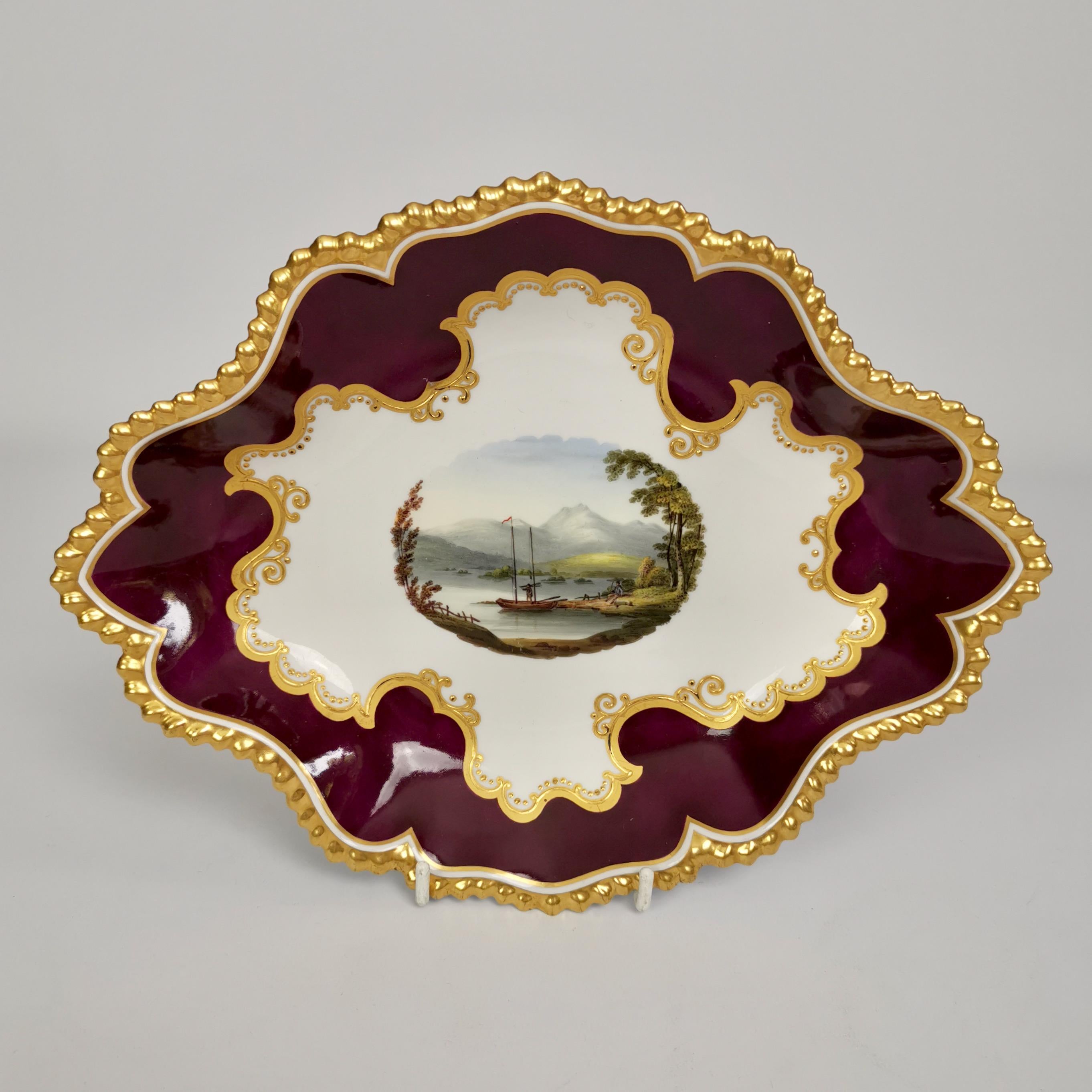 This is a beautiful set of a serving dish and two dessert plates made by Flight, Barr & Barr between 1813 and 1840, most probably in the 1820s. The set has gadrooned rims, a beautiful deep maroon ground and stunning hand painted landscapes.
