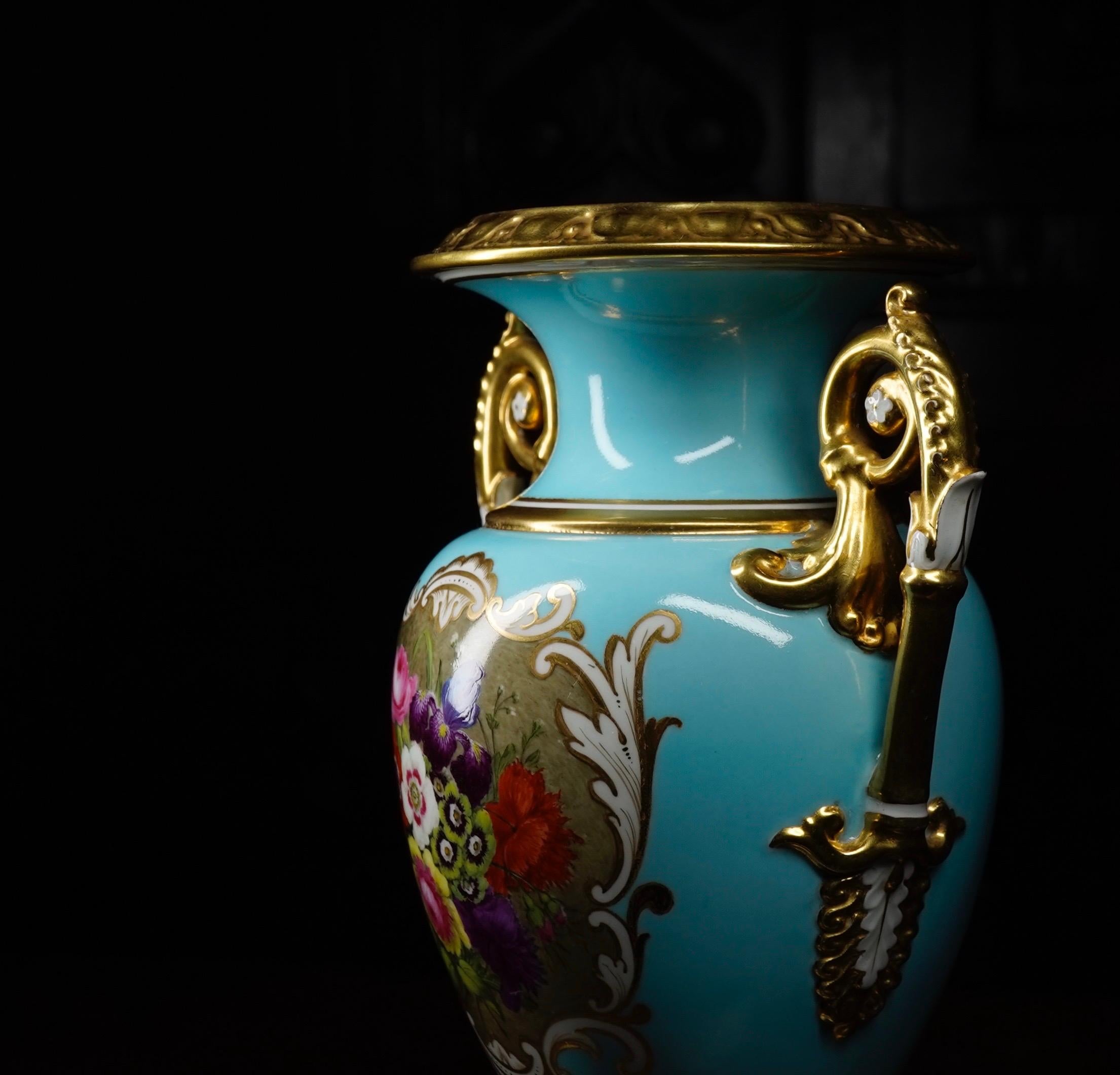 Handsome Flight Barr & Barr vase, the Amphora form with twin gilt scroll handles and square plinth base, a wide moulded & gilt egg-and-dart rim with fine anthemion gilding inside, the duck-egg blue body reserved with a panel of superb flowers framed