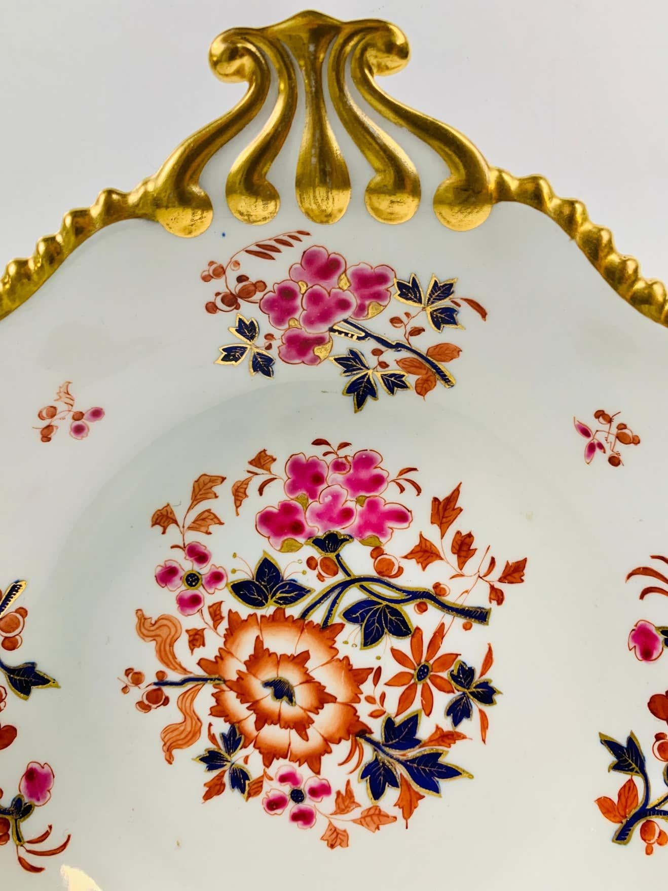 This George IV shell-shaped dish was made in the Flight Barr and Barr Worcester factory circa 1820.
The colors are exquisite. A ring of hand-painted flowers fills the border.
This shell-shaped dish is in excellent condition. 
Dimensions: 8.5