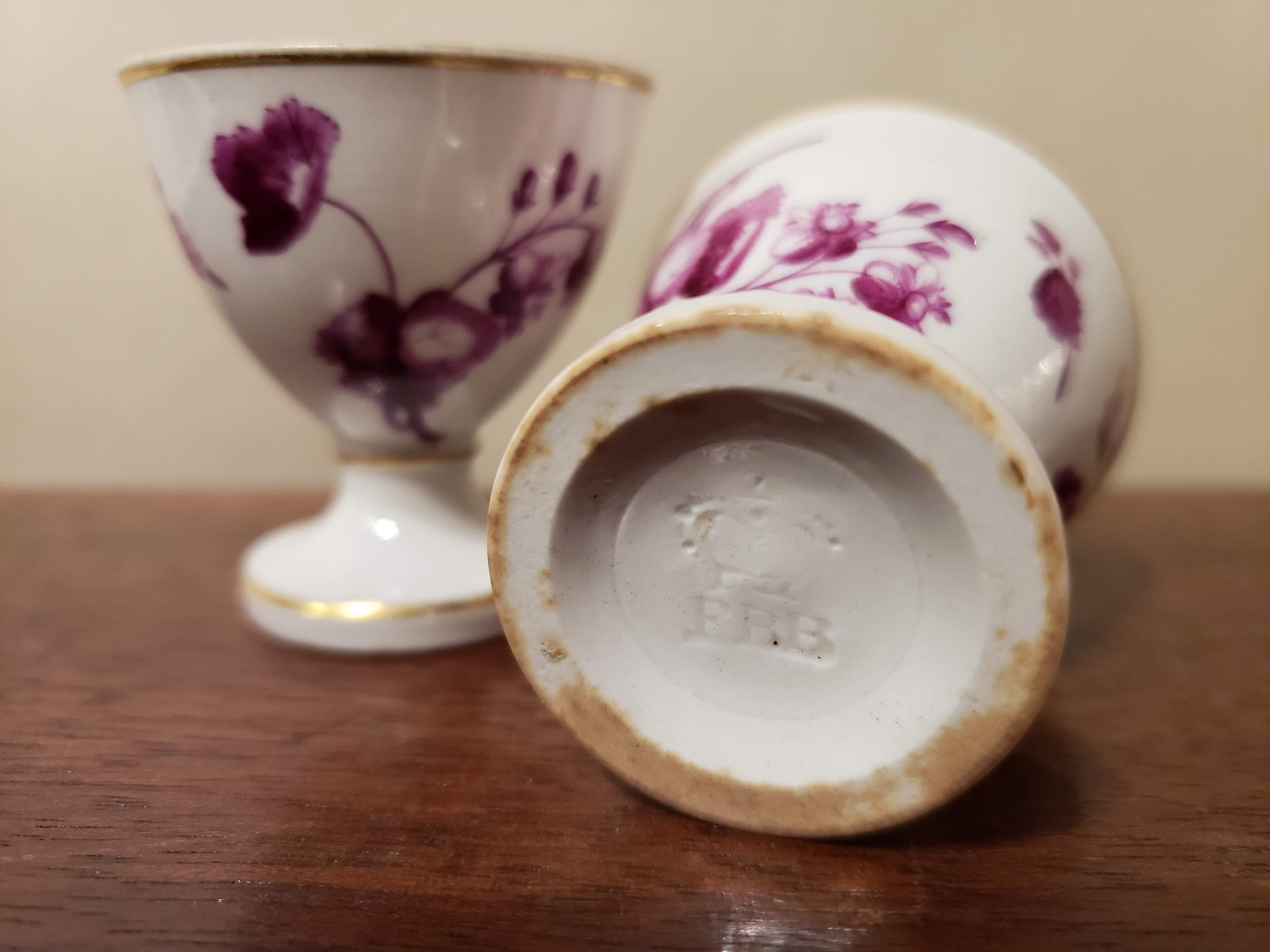 Flight, Barr & Barr Worcester porcelain egg cups decorated with puce flowers,
circa 1804-1813

The rare Flight, Barr & Barr Worcester porcelain egg cups are waisted with a flared foot and upper bowl which is painted with pure flowers and