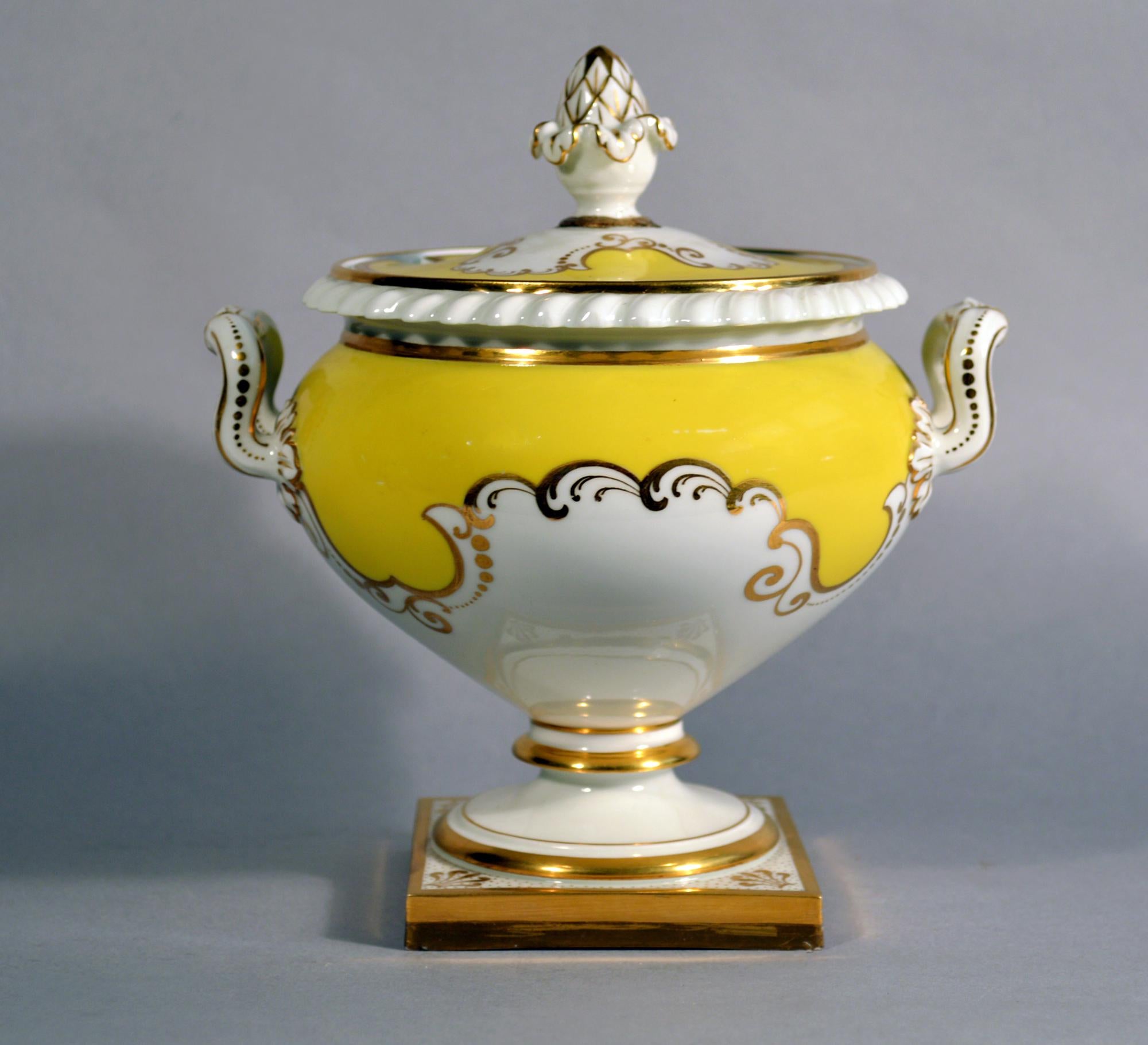 Soupière et couvercle pour sauce jaune en porcelaine de Worcester Flight, Barr & Barr,
Vers 1825.

La soupière est peinte d'un fond jaune et de rinceaux dorés et repose sur une base carrée dont chaque coin est peint d'une coquille dorée. La