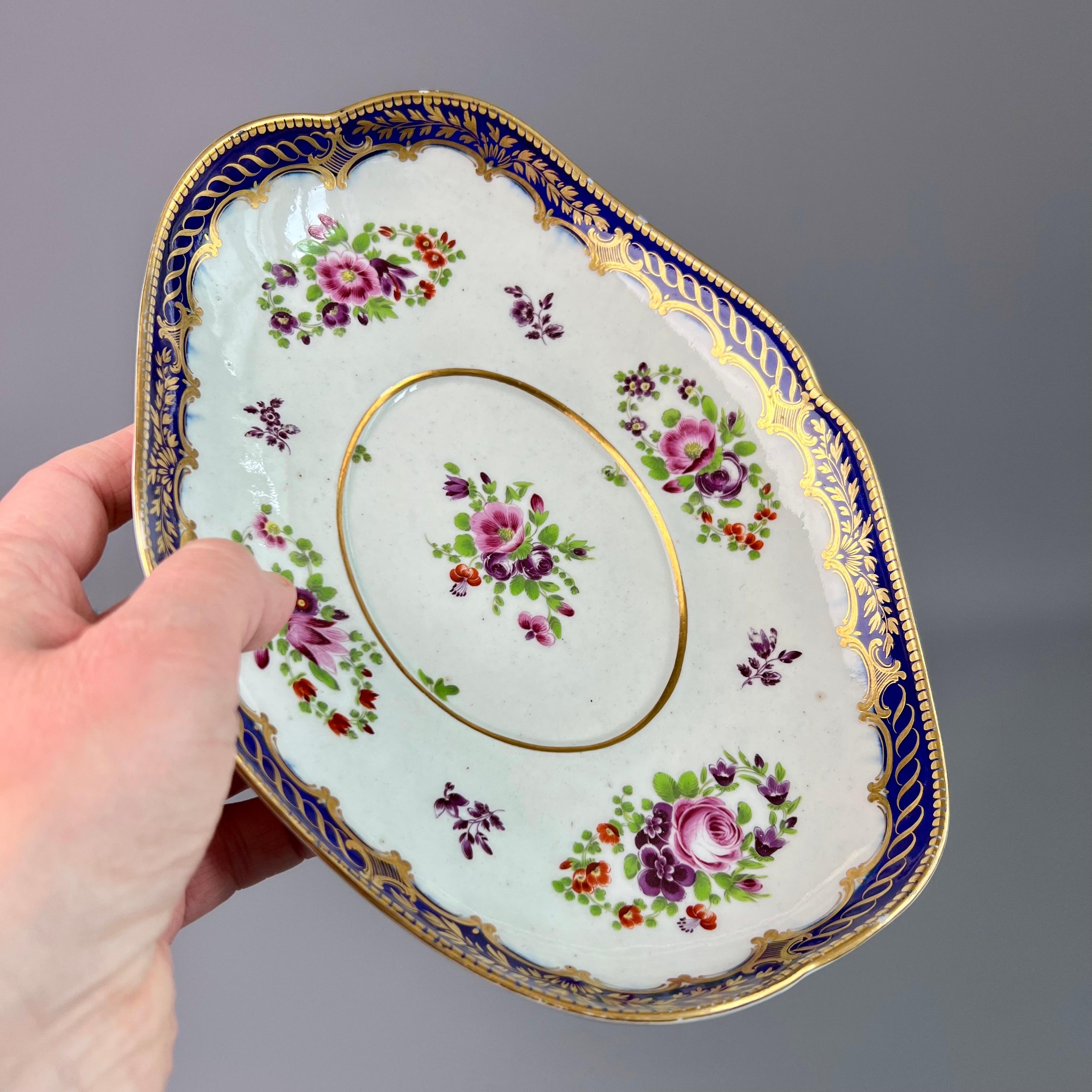 This is a beautiful oval dish or stand made by Flight in Worcester probably around the year 1785. The dish is decorated with a mazarine and gilt rim and has beautiful hand painted flower sprays. It carries an underglaze open crescent mark.

This