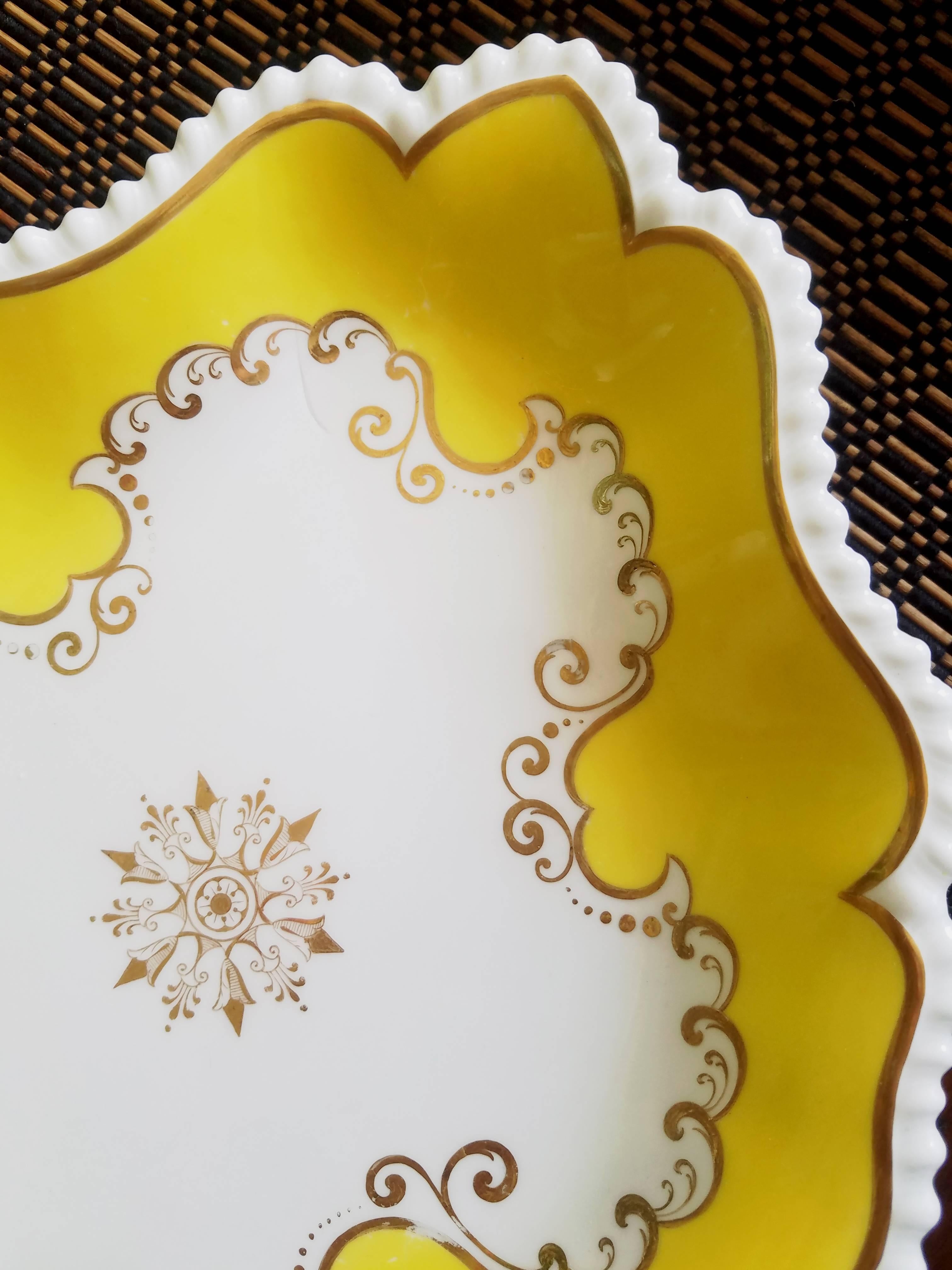 Flight, Barr & Barr Worcester yellow oval porcelain dishes, 
circa 1820.

The oval porcelain dishes with an impressed FBB mark have a shaped, crimped border with a thin gilt band encircling the dish. The center has a painted gilt star design with