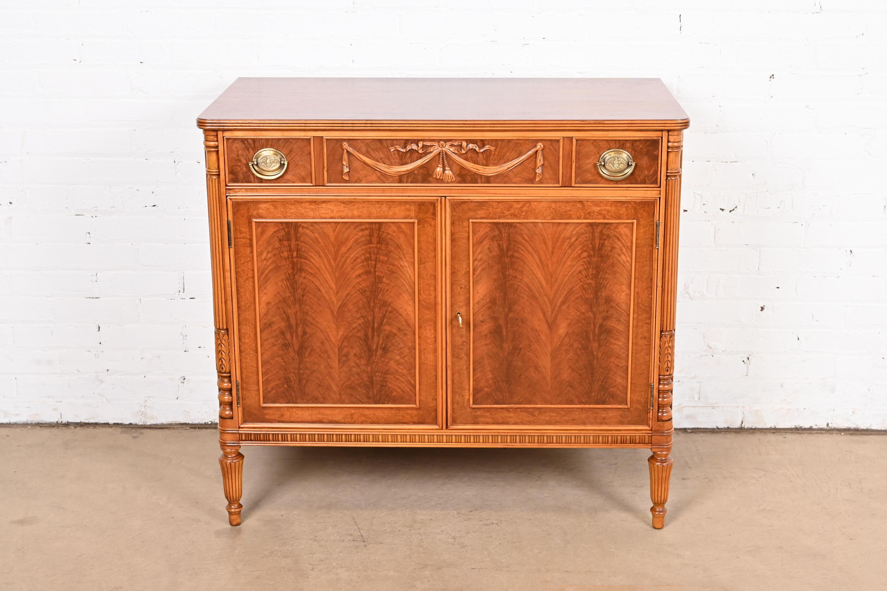 A gorgeous antique French Regency Louis XVI style buffet server or bar cabinet

By Flint & Horner

USA, Circa 1930s

Beautiful book-matched burled walnut, with original brass hardware.

Measures: 38