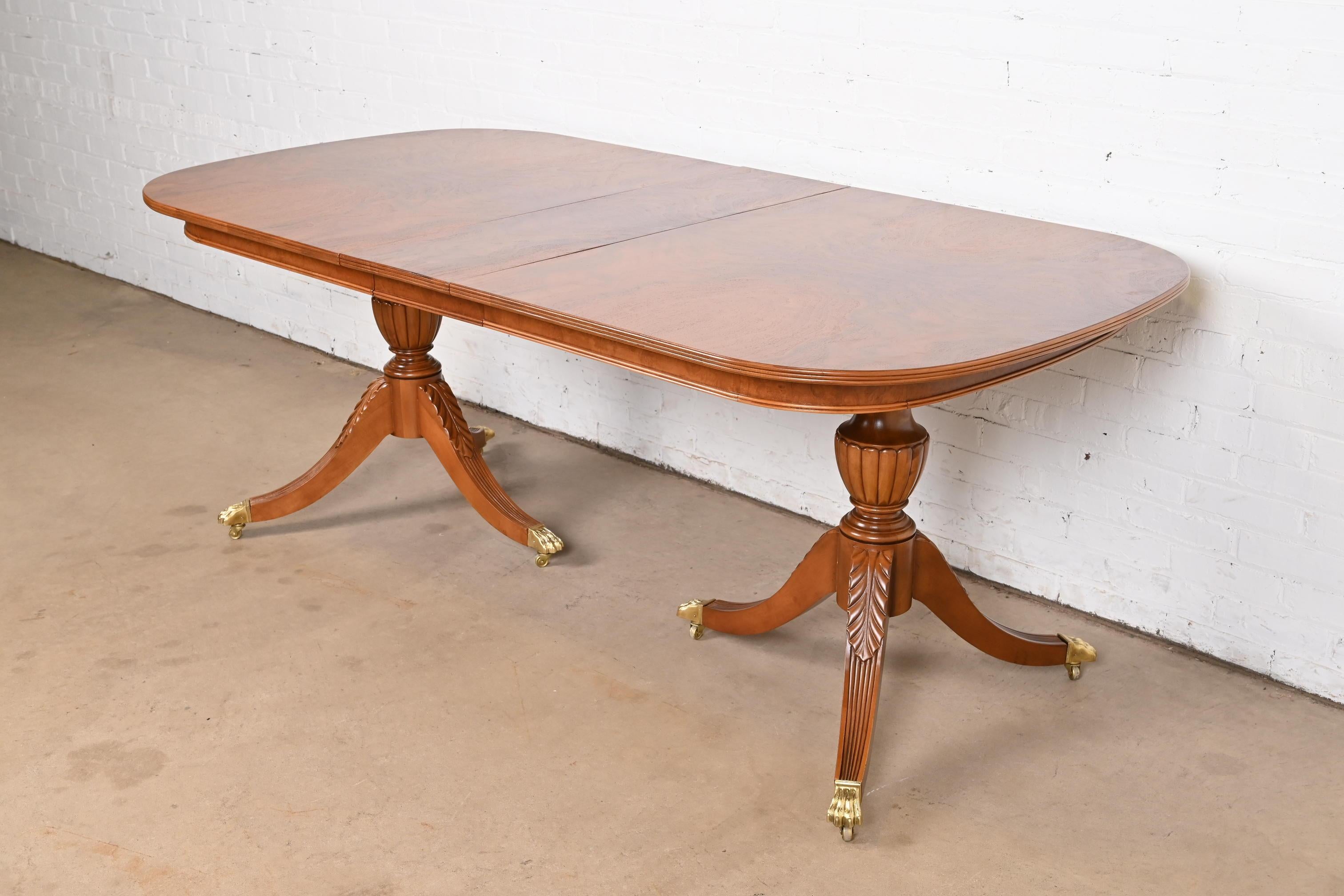 Exceptionnelle table de salle à manger à double piédestal de style géorgien ou régence.

Par Flint & Horner

USA, Circa 1930s

Magnifique plateau en noyer ronceux assorti à un livre, avec des piédestaux en acajou massif sculpté et des pieds en