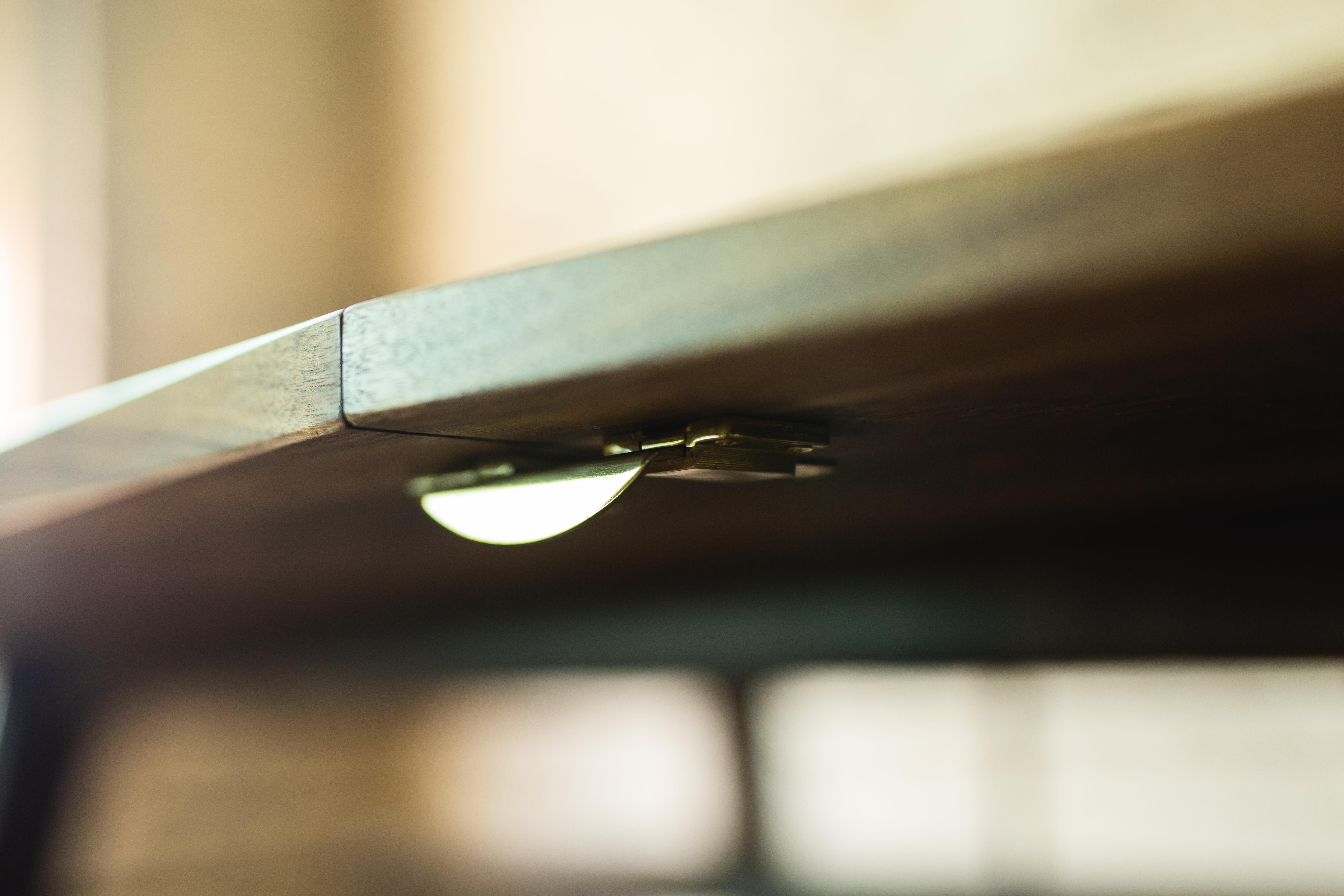 Moderner ausziehbarer Flint-Tisch aus Nussbaumholz mit Messingverbindungen im Angebot 1