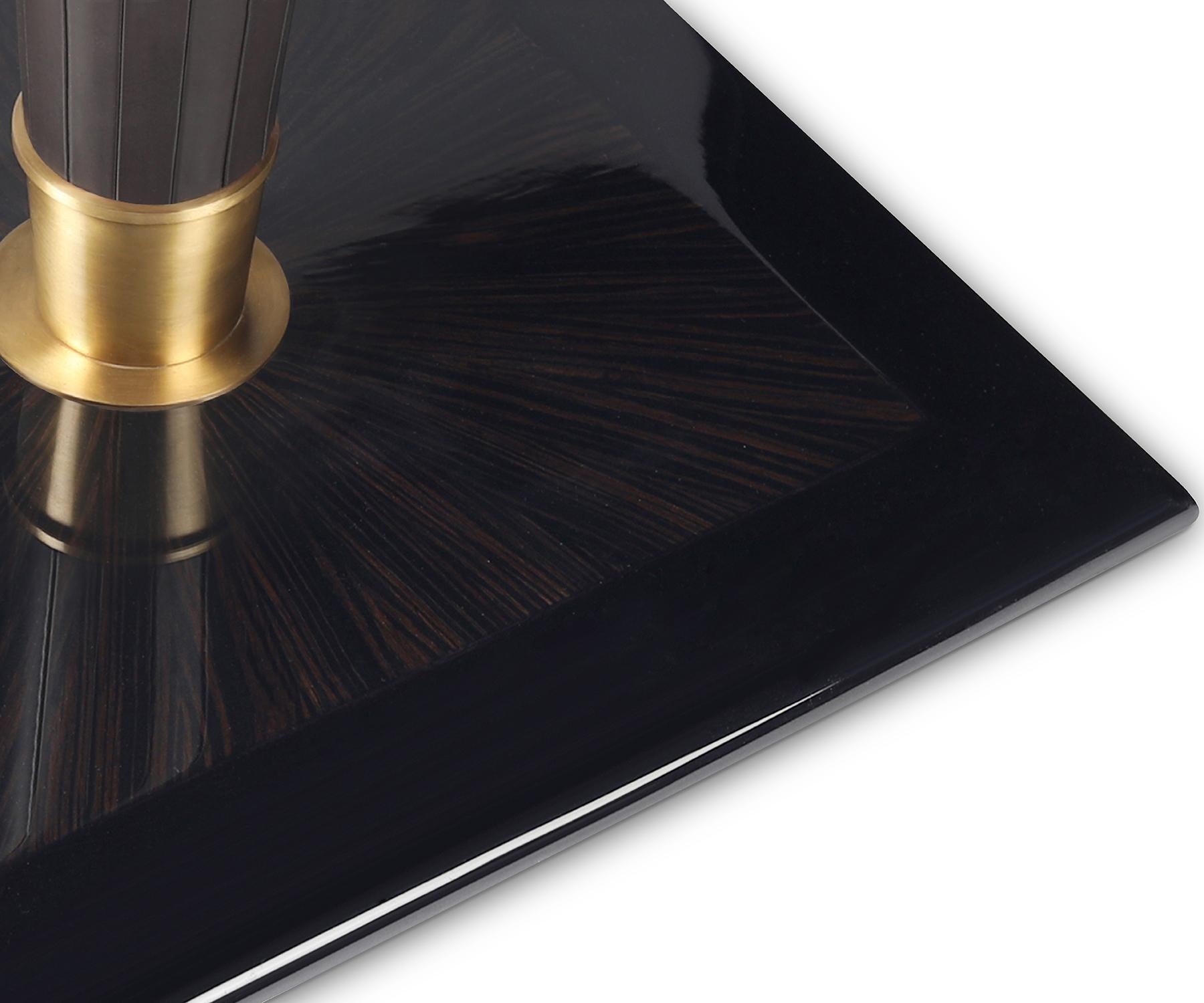 The Flint table captivates with its geometric design and mix of materials.

The square tabletop features sunburst veneer marquetry, while the apron showcases grecco styled leather detailing. Its tapered pedestal leg, wrapped in leather, flows