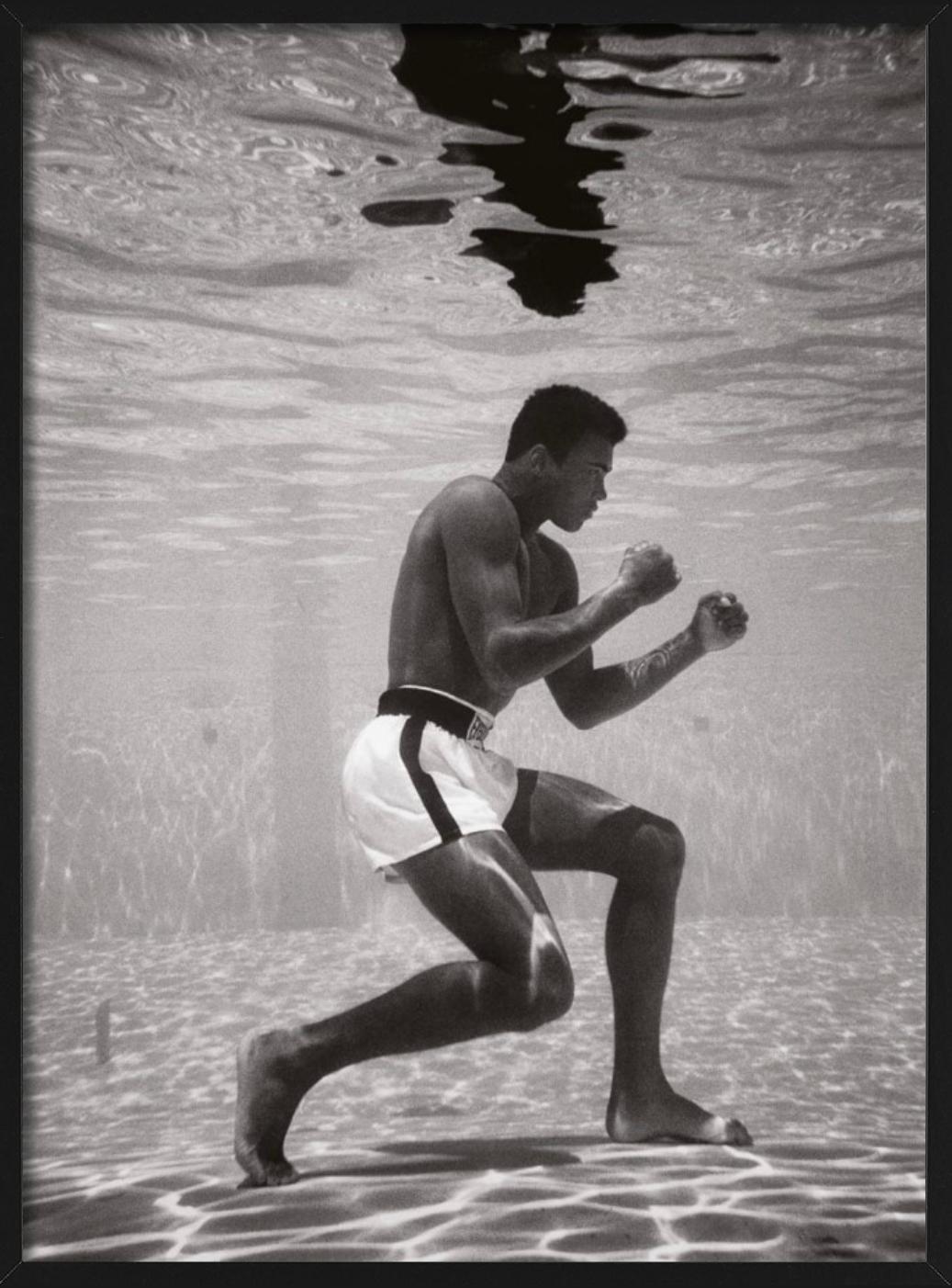 Ali Underwater - le boxeur Muhammad Ali s'entraîne sous l'eau dans une piscine - Gris Black and White Photograph par Flip Schulke