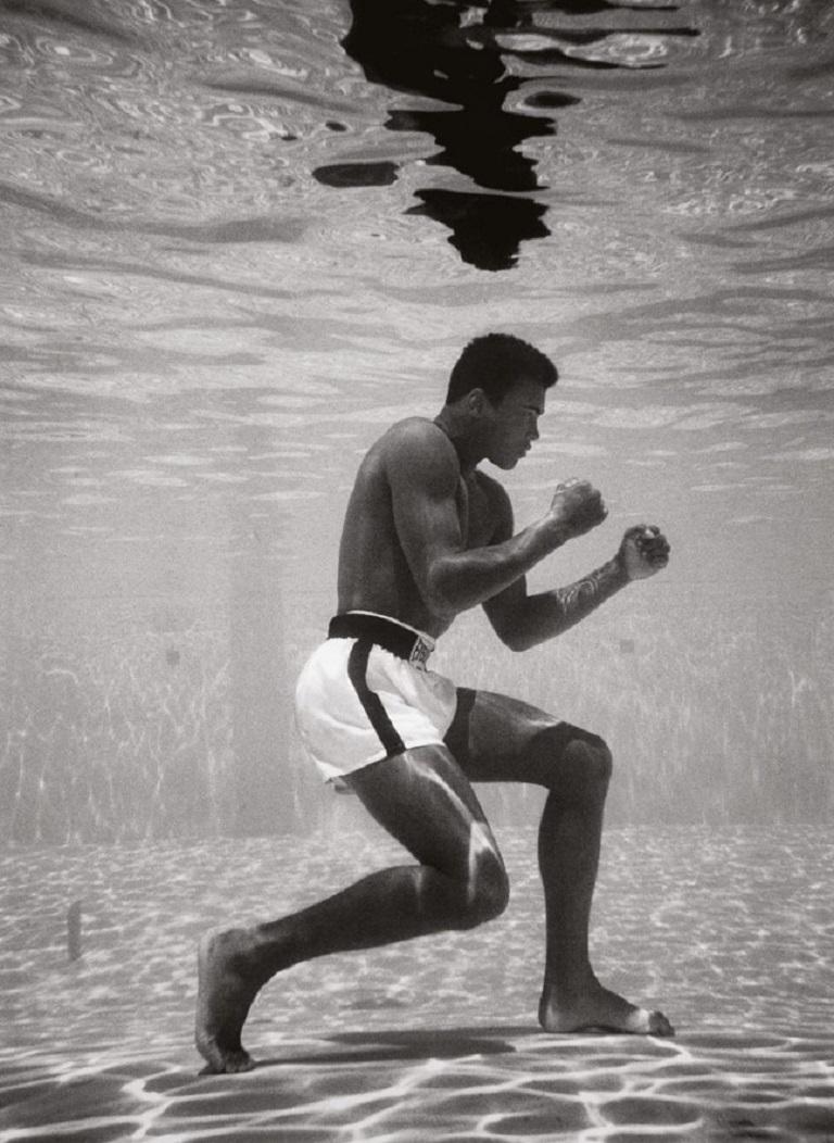 Black and White Photograph Flip Schulke - Ali Underwater - le boxeur Muhammad Ali s
entraîne sous l
eau dans une piscine