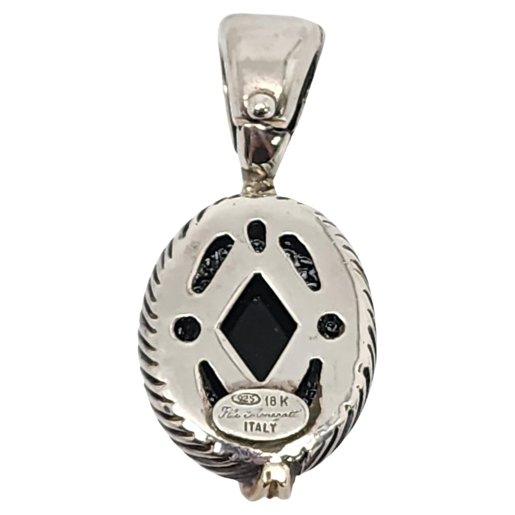 Sterling silver 18K onyx enhancer pendant by Flli Menegatti.

Oval black onyx set in sterling silver textured pendant with 18K yellow gold accents. Hinged bale.

Measures approx 1 5/8
