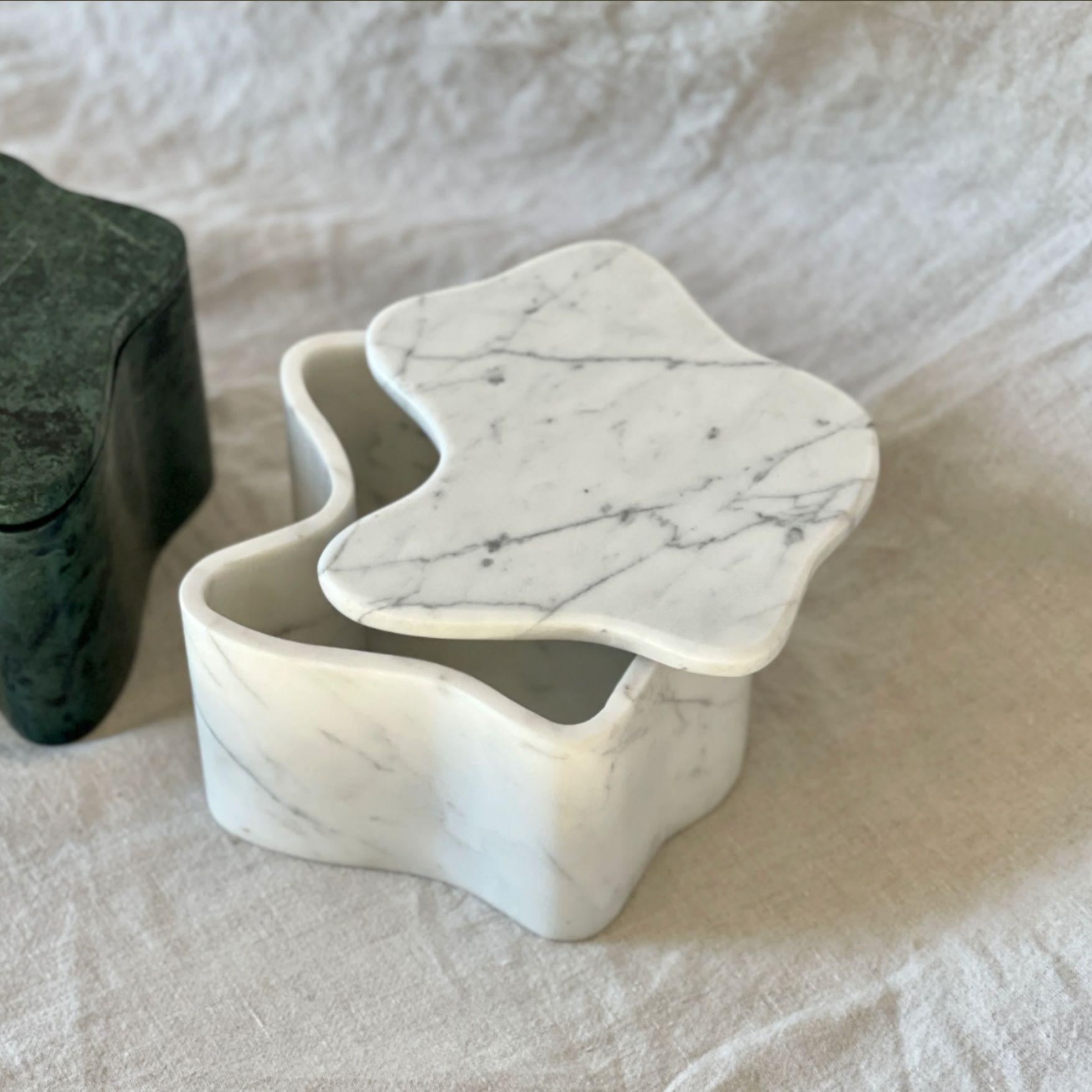 Voici la boîte Flo, signée Anastasio Home. Fabriqué à la main à partir d'un seul bloc de marbre exquis, ce pot de toilette à couvercle est une création unique. 

Avec son poids substantiel et sa présence imposante, il sert non seulement de