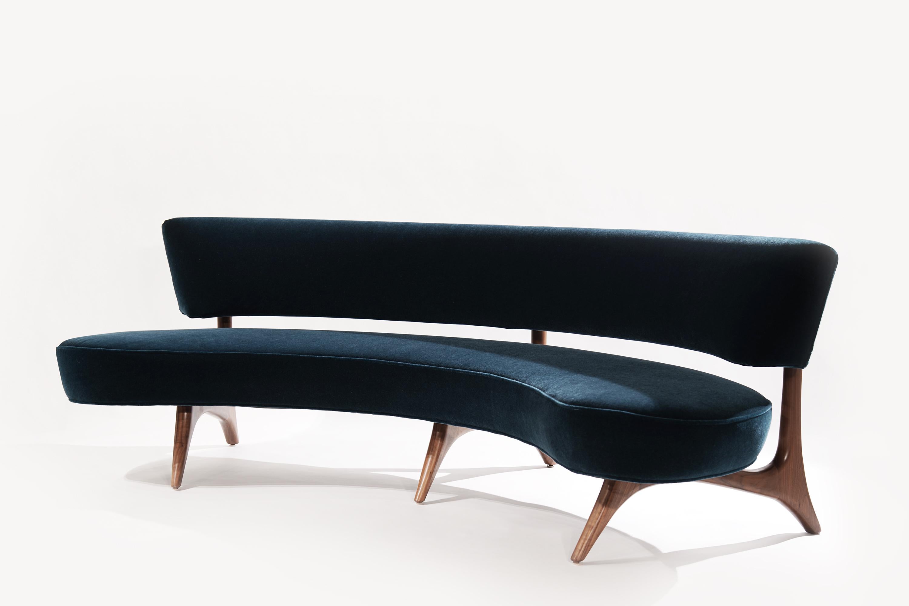 First designed in 1952, the Floating Curved Sofa united two early Kagan signatures with its curved shape and elegantly sculpted walnut frame. The floating backrest invites placement away from the walls, with negative spaces that allow glimpses of