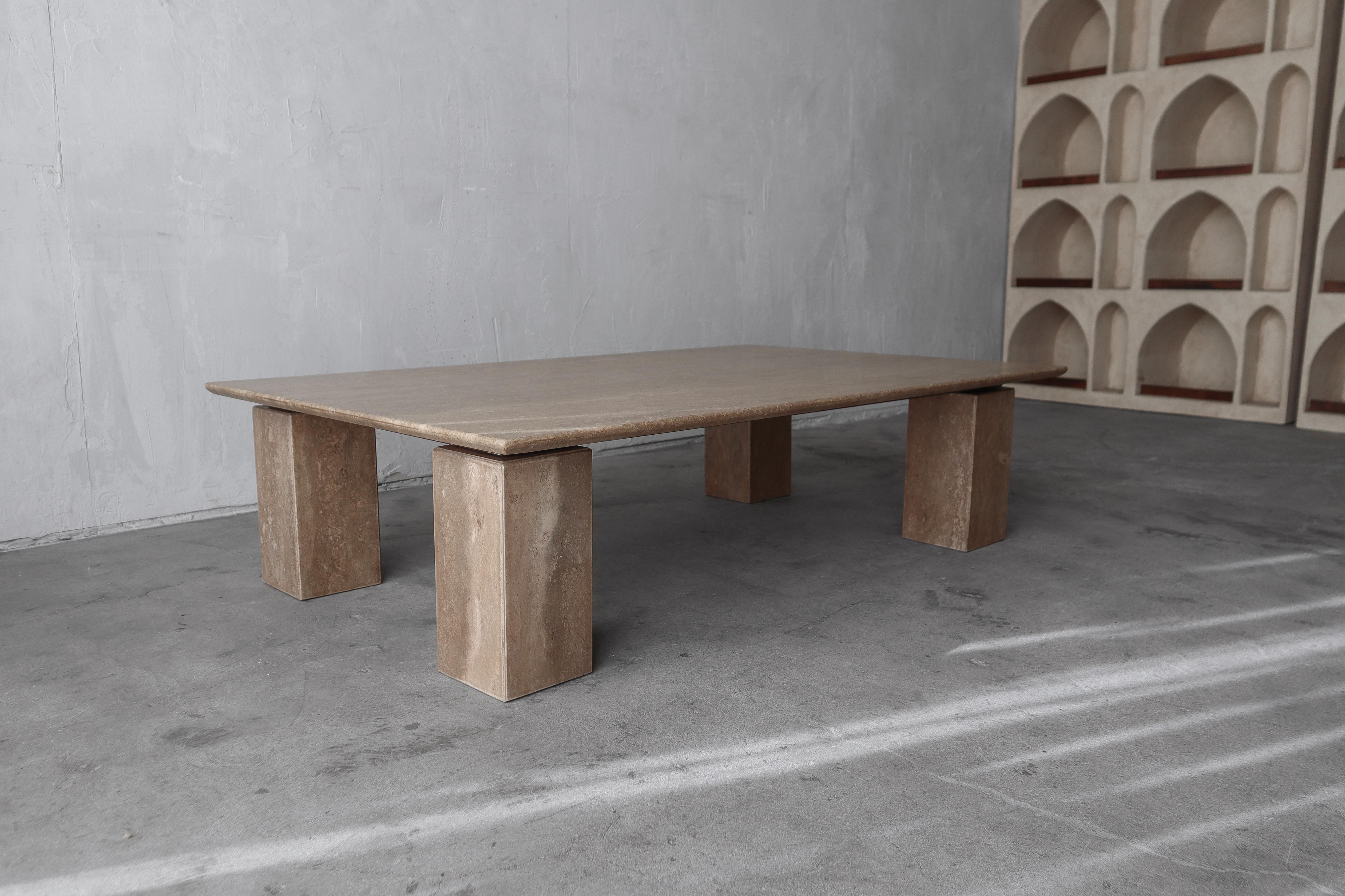 Nous adorons cette table basse flottante en travertin brun. La table est d'une grande beauté, elle repose sur une armature en métal chocolat qui la suspend sur ses pieds colonnaires.  Cette table est la pièce parfaite si vous avez besoin d'une pièce