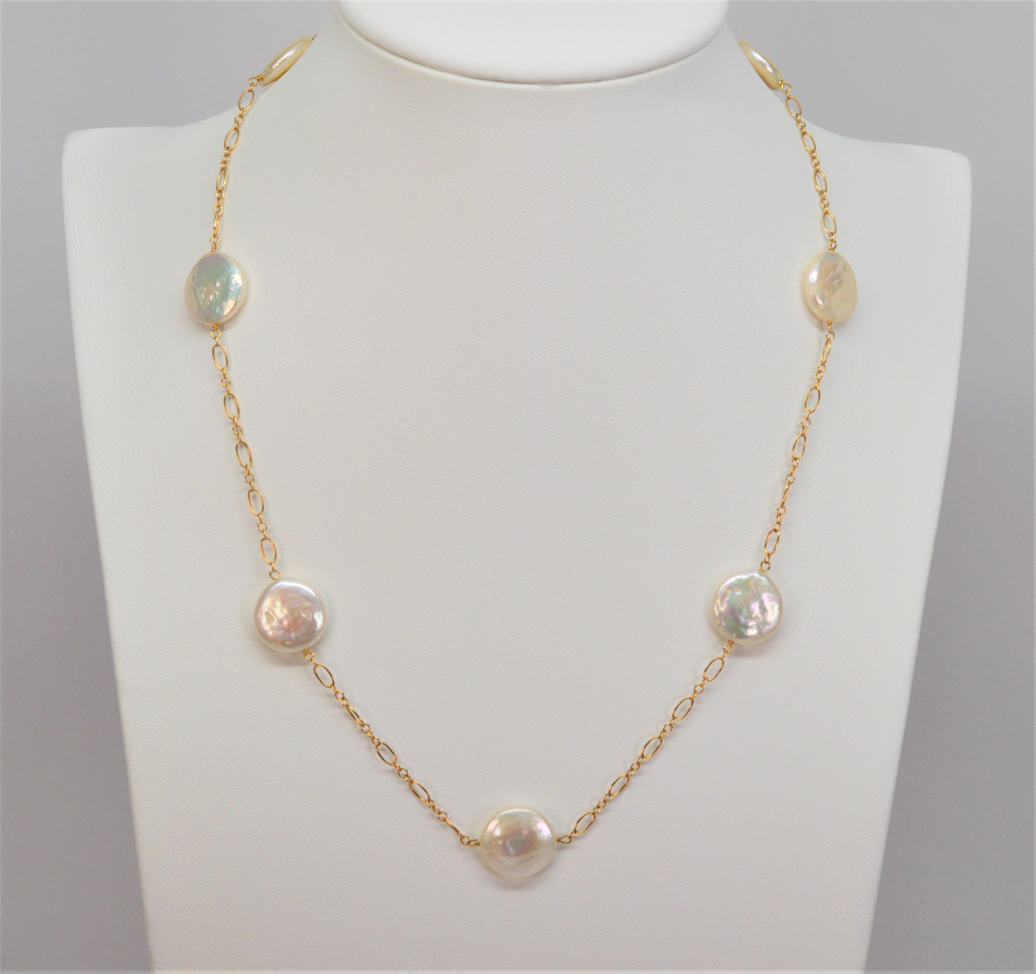 The rainbow iridescence of these natural coin pearls can be truly appreciated stationed along its 14 karat yellow gold chain. Each round coin pearl measures approximately 13.2mm and floats on a 16 inch with easy lobster clasp. New, gift boxed.  