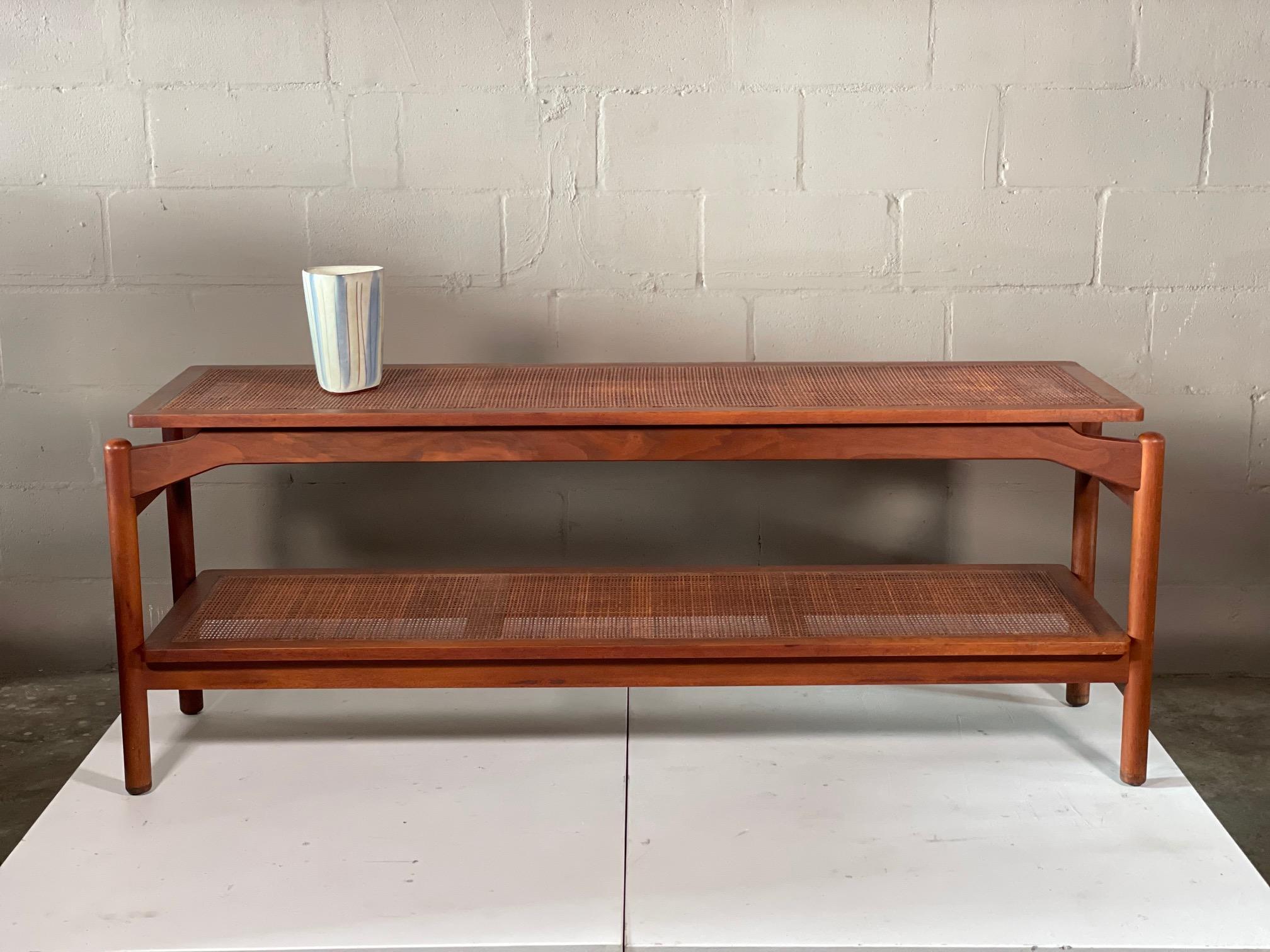 An unusual floating console table by Greta Grossman for Glenn of California. Caned top and bottom shelves.