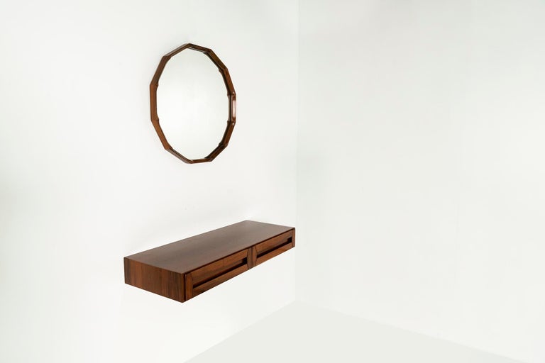 This refined console and ditto mirror were designed by Dino Cavalli in the 1960s and exude a great allure. The veneer, which consists entirely of walnut, is beautifully executed in detail. The color shades of the wood that go from a combination of