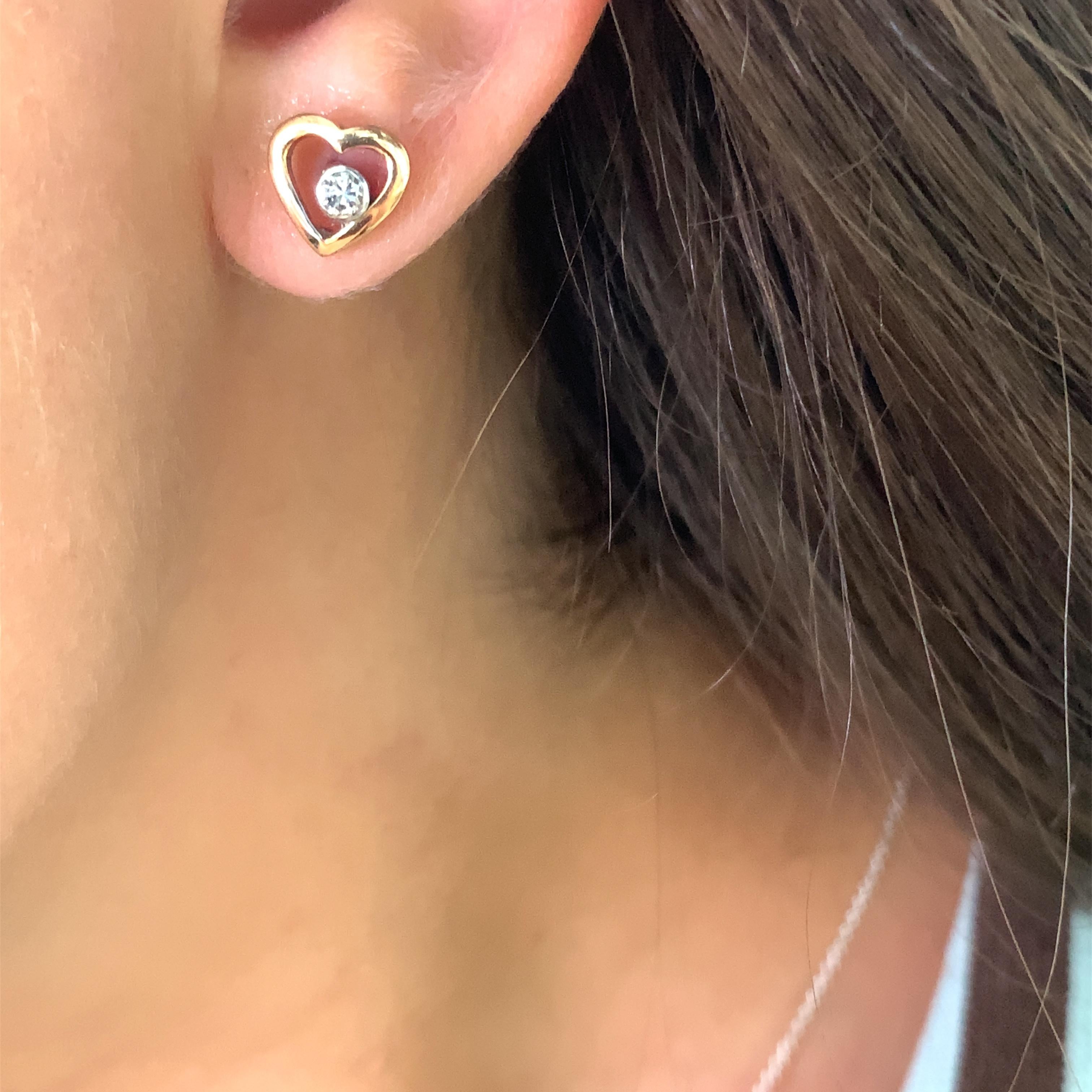 Questi splendidi orecchini a forma di cuore con perno di diamante sono un must per ogni collezione di gioielli. Con un peso totale di 0,25 carati, questi orecchini presentano due diamanti a taglio rotondo con un'intensità di colore F e un grado di