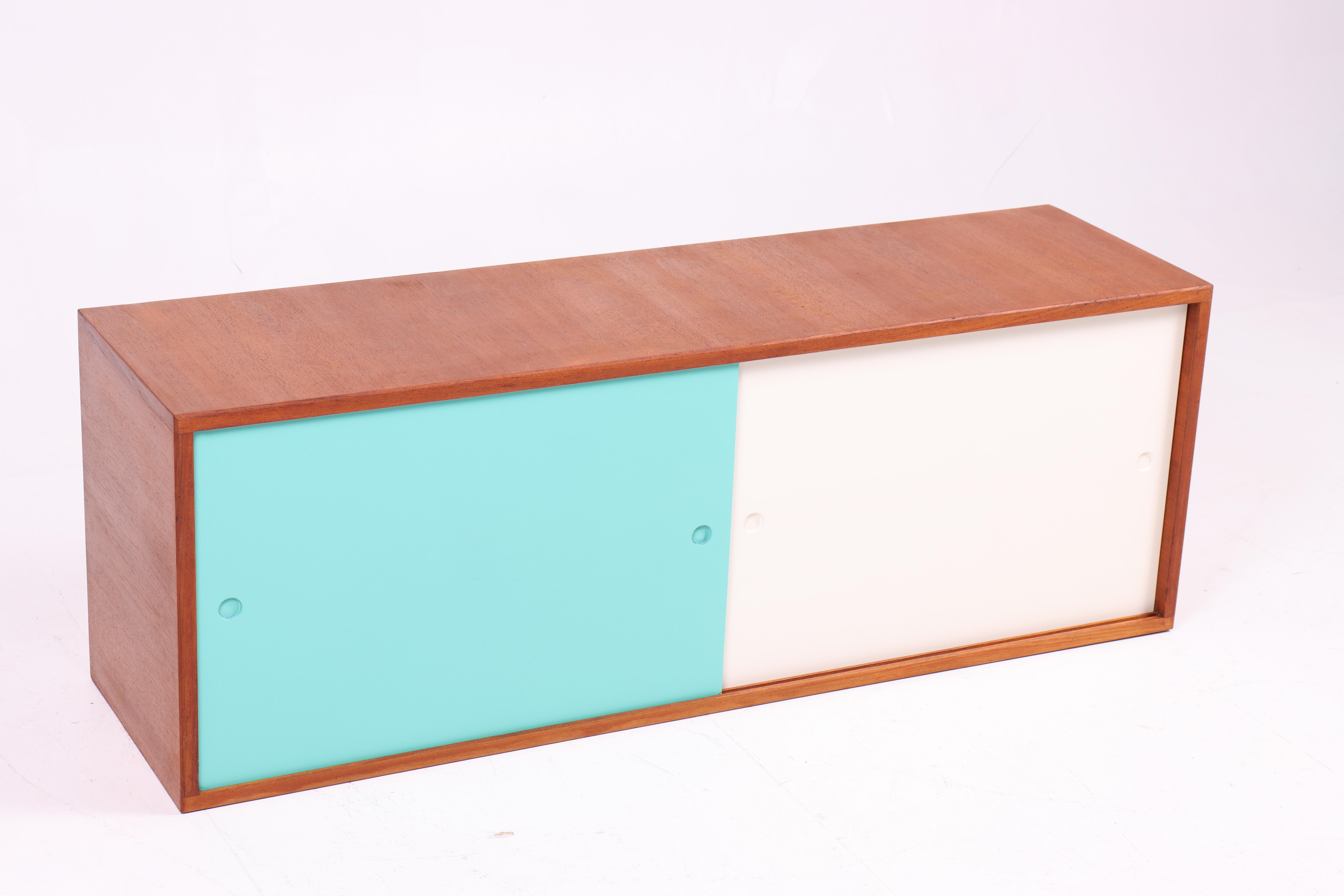 Credenza a muro in teak con pannelli laccati. Progettata e realizzata dallo studio di design Heinrich Roepstorff in Danimarca negli anni '50. Ottime condizioni originali.