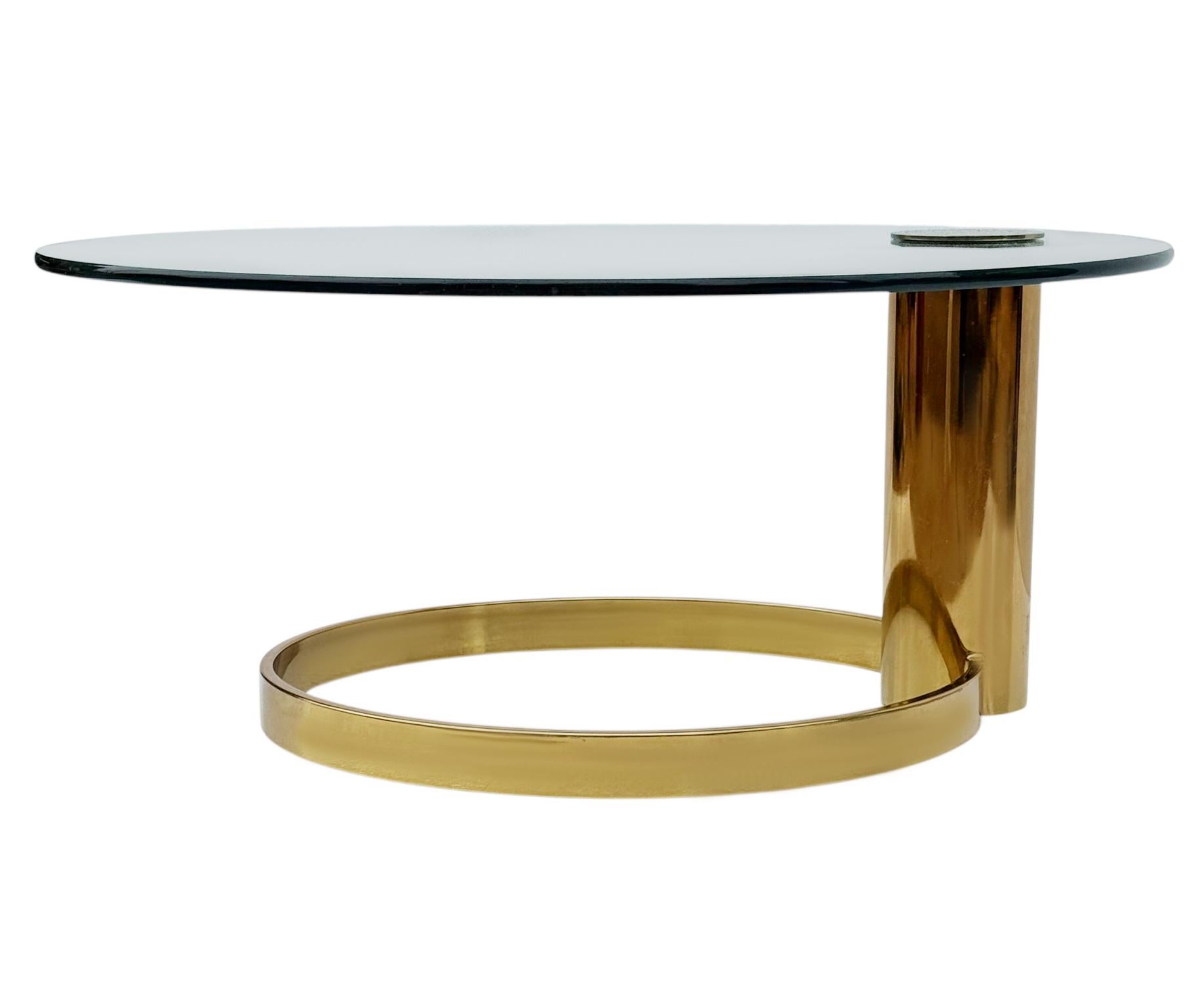 Une table basse de plus petite taille conçue par Leon Rosen pour la Collectional. Il est doté d'un plateau en verre flottant très épais sur une base en acier plaqué laiton. 

