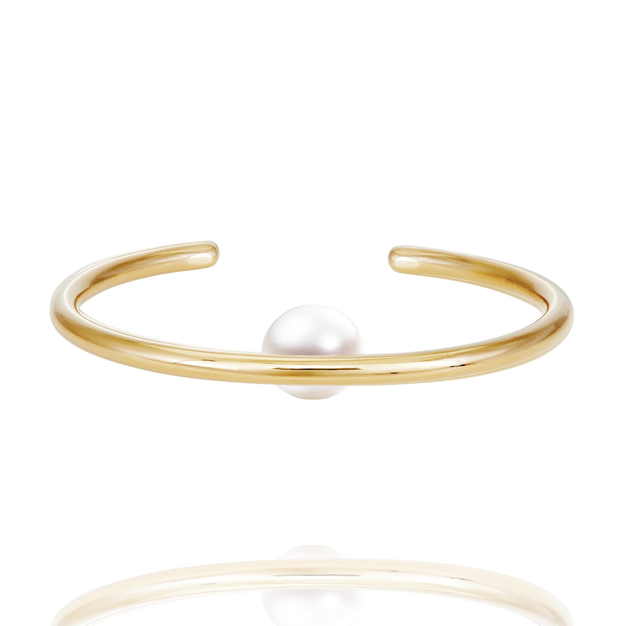 Le bracelet manchette en or 14k avec perles flottantes est un luxueux bijou de haute joaillerie en or massif 14k avec des perles d'eau douce de 13 mm.  Inspirée du surréalisme, cette pièce est conçue pour 