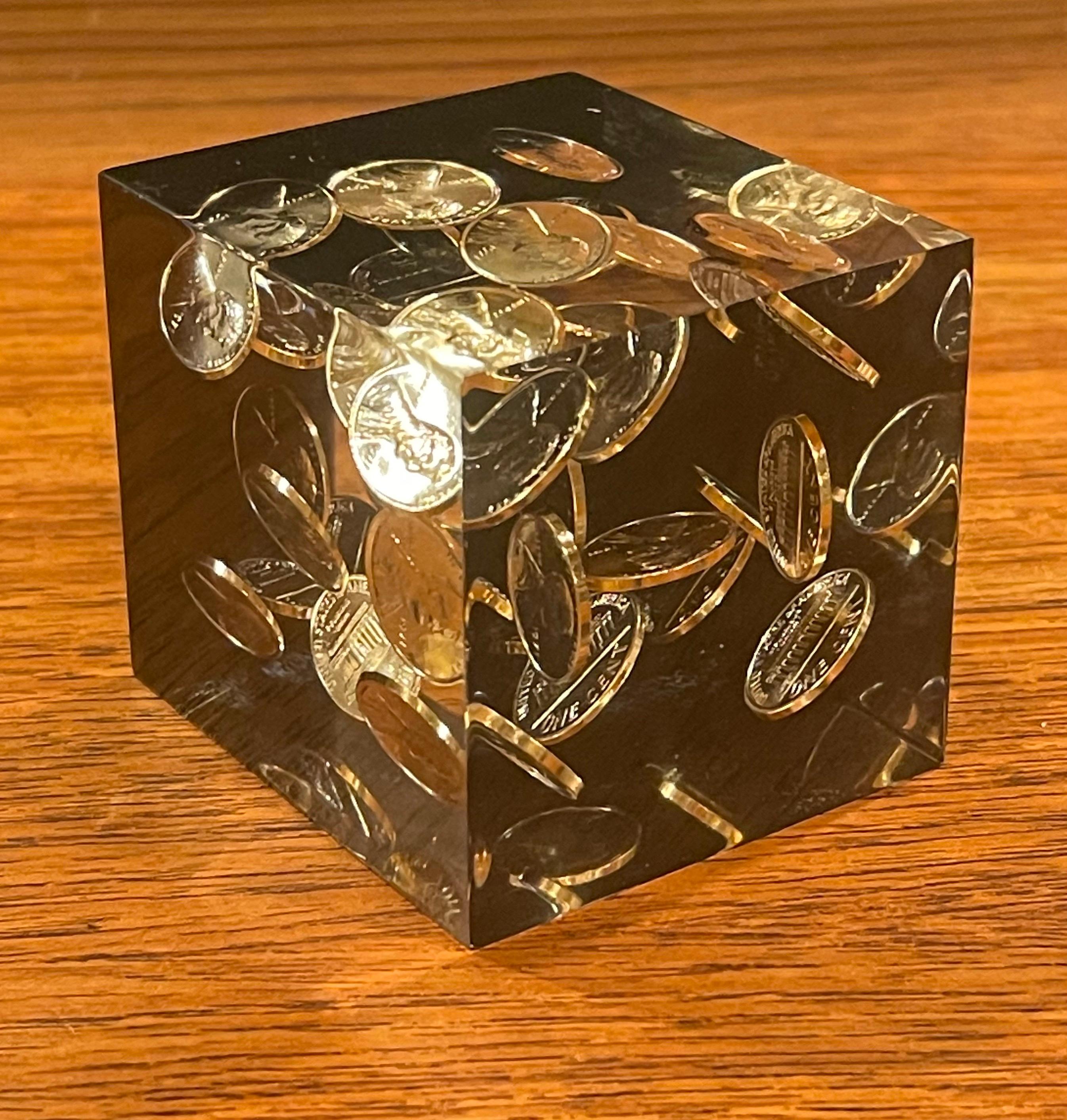 Floating pennies in lucite cube paperweight in the style of William Rolfe, circa 1980s. The pice is in very good vintage condition and measures 2.5