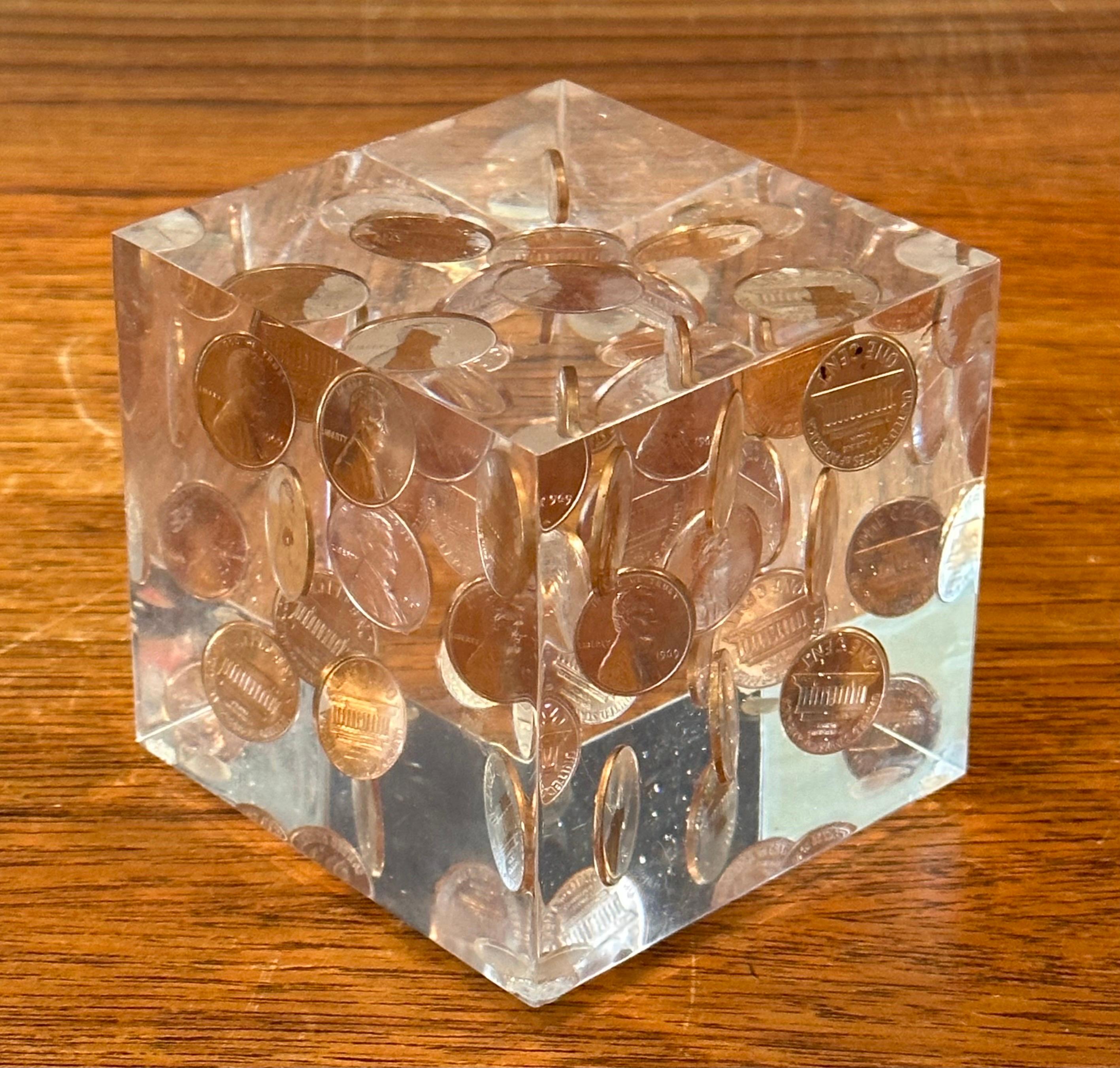 A very cool floating uncirculated 1969 pennies in lucite cube paperweight in the style of William Rolfe, circa 1970s. The piece is in very good vintage condition with no chips or crazing and measures 3.125