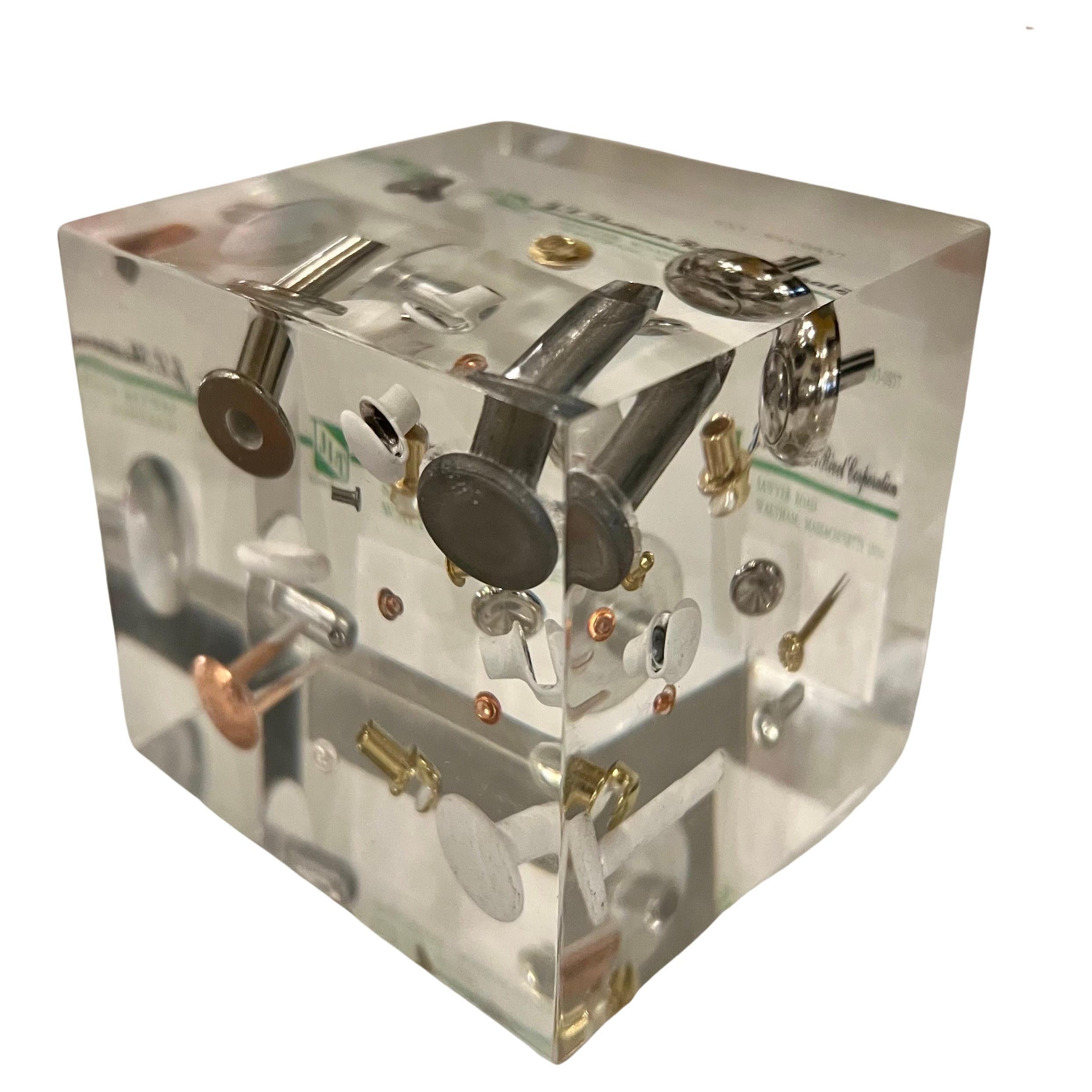 Rivetti fluttuanti in un cubo pubblicitario in lucite nello stile di William Rolfe