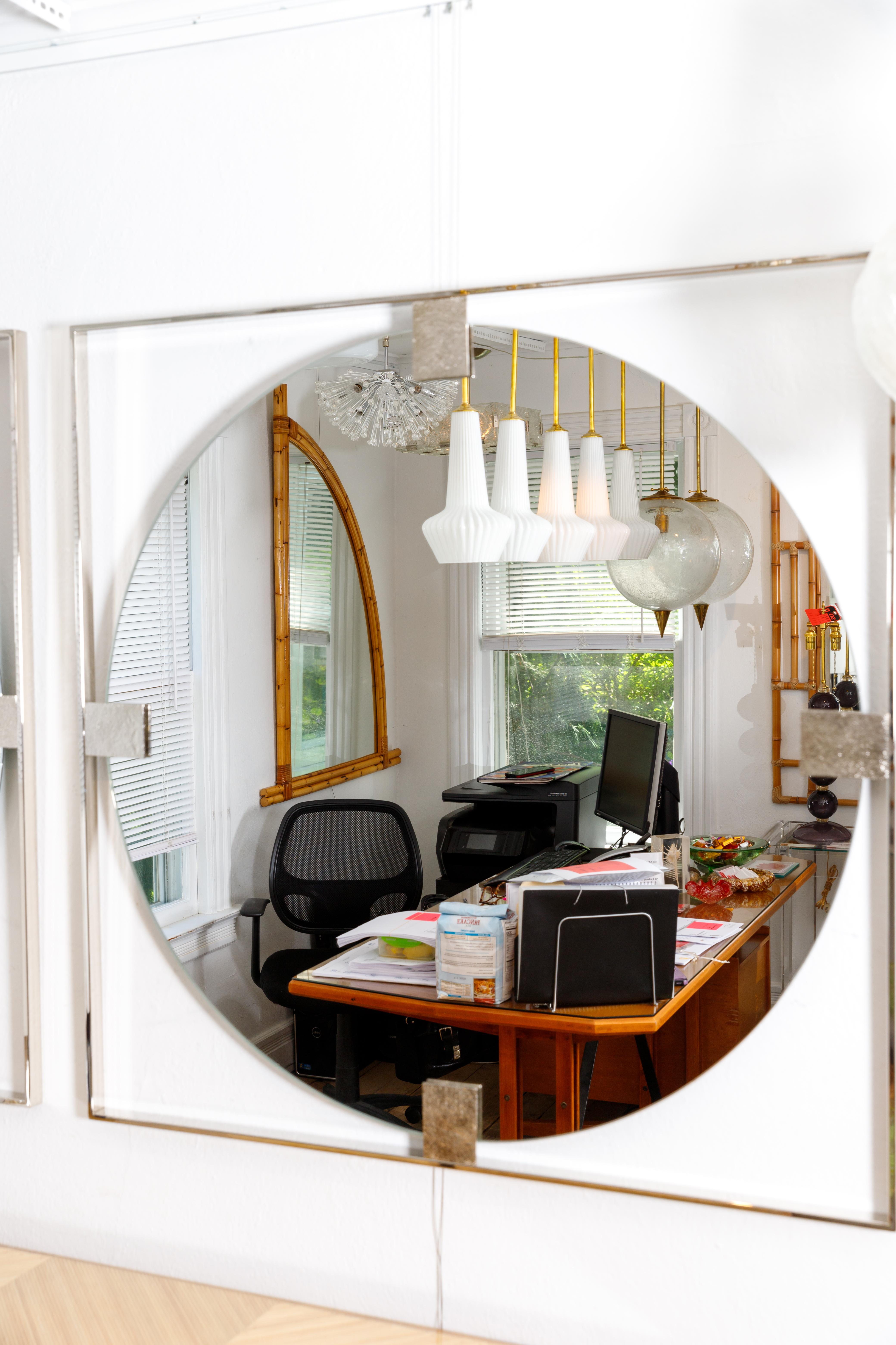 Floating round mirror with nickel surround and embossed detail.