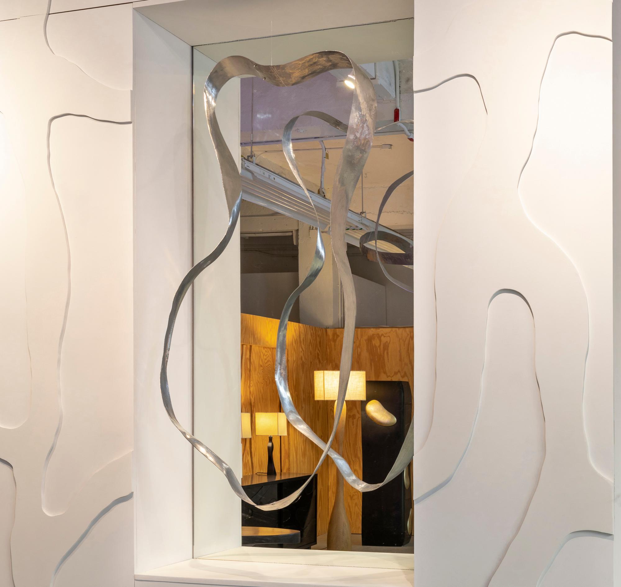 Jacques Jarrige created this hand-hammered aluminum sculpture as a floating, kinetic frame for a fireplace mirror.



The form is evocative of the human body—its curves and gestures shaped by motion. Each hammer strike leaves behind subtle