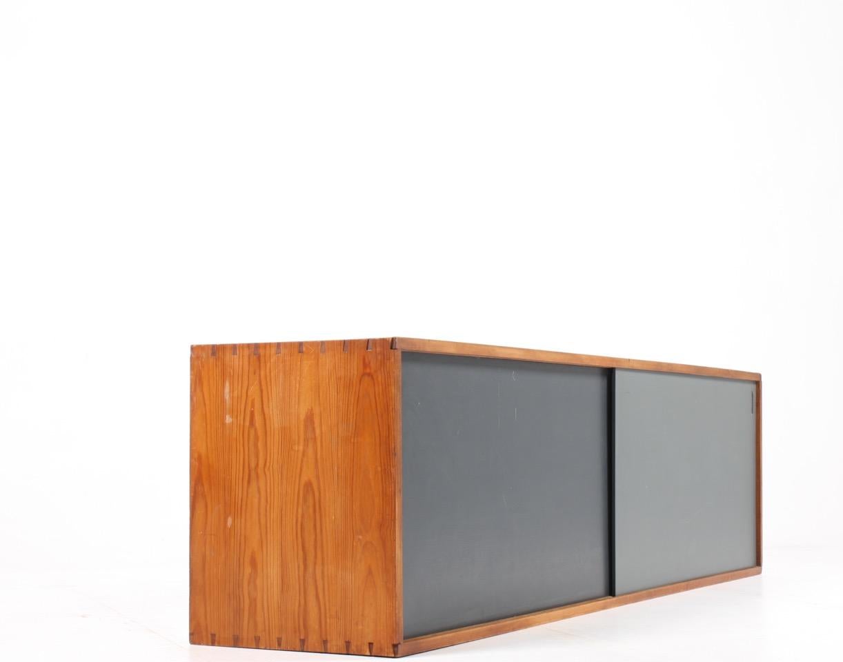 Wall-mounted sideboard in solid pine with lacquered panels. Designed and made by Henrik Iversen and Harrald Plum in the 1950s. Original condition.