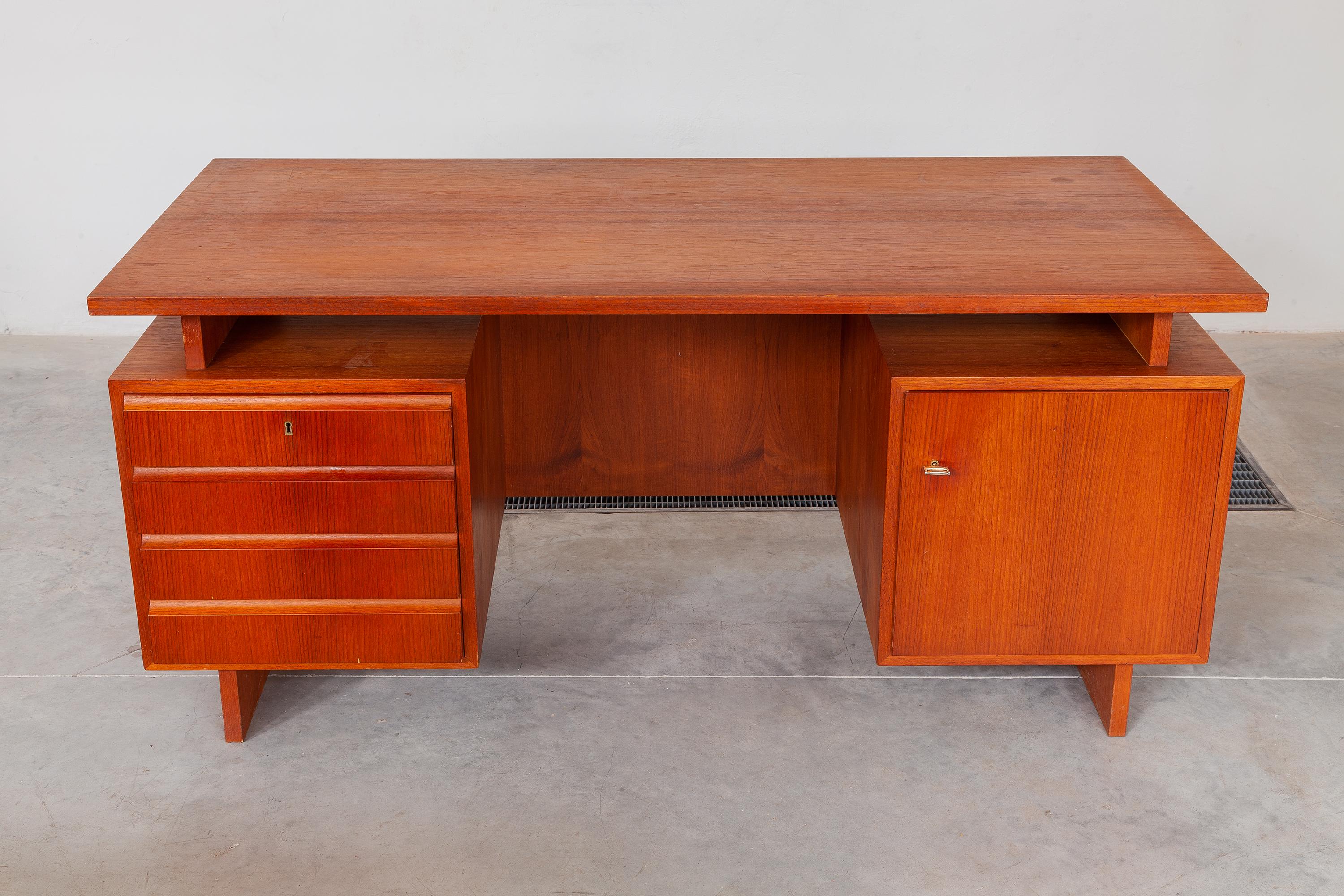 Vintage midcentury teak desk. The floating top design rests on one large cabinet with one shelve and one with four drawers. Dimensions: 160 W x 74 H x 80 D cm.