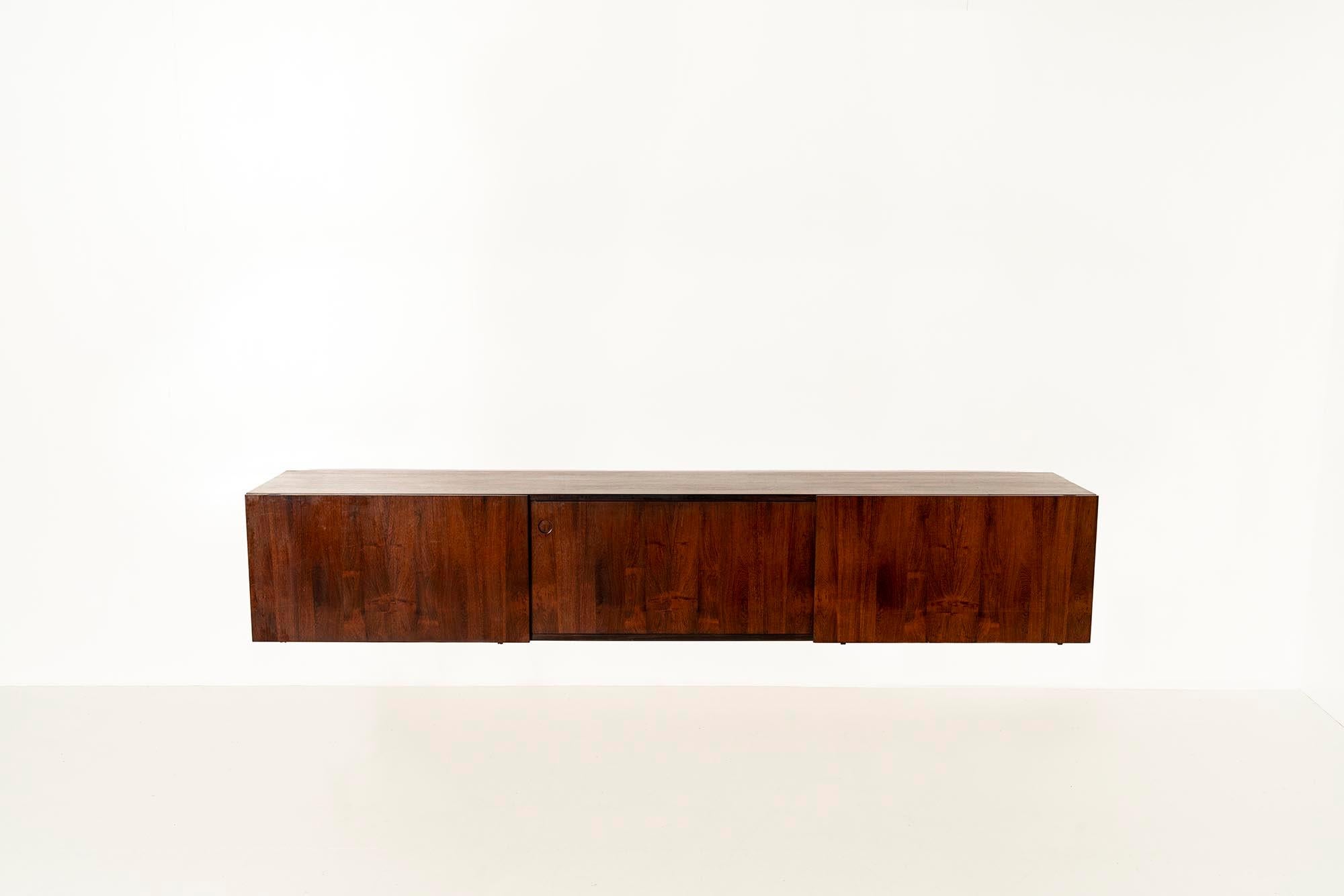 Elegant Danish floating wall-mounted sideboard by IB Kofod Larsen from the 1970s.

This beautiful sideboard is finished in rosewood veneer. Showing an intriguing and similar pattern on the sliding doors that close off the three separate