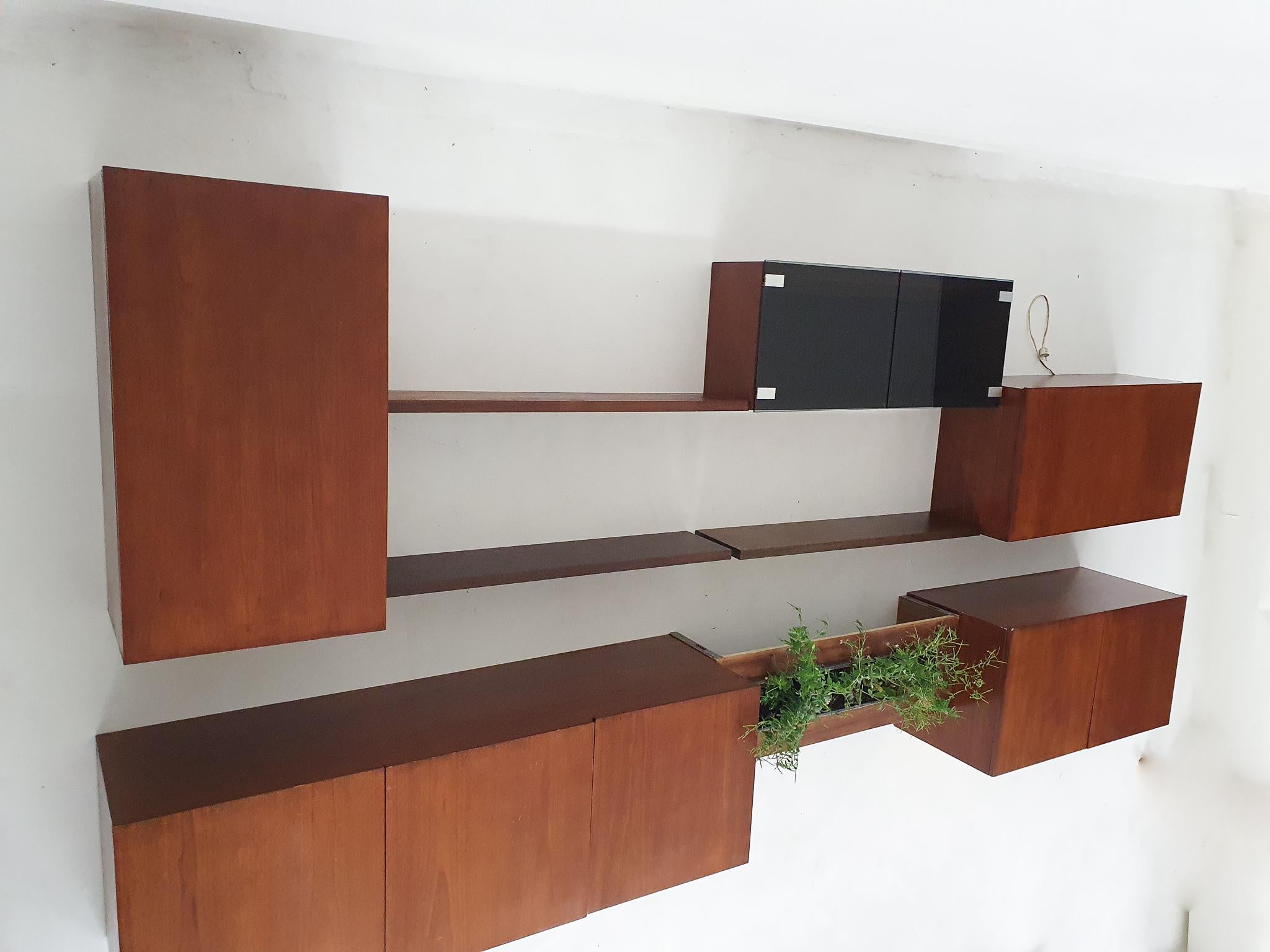 Floating wall unit in teak by Banz Bord, Holland.
The wall unit is photographed on the floor.
The cabinets and shelves can be hung as desired.

The wall unit consist of:
1 long cabinet: 150 x 45 x 50 cm (LxDxH)
1 high cabinet: 50 x 33.5 x 90 cm