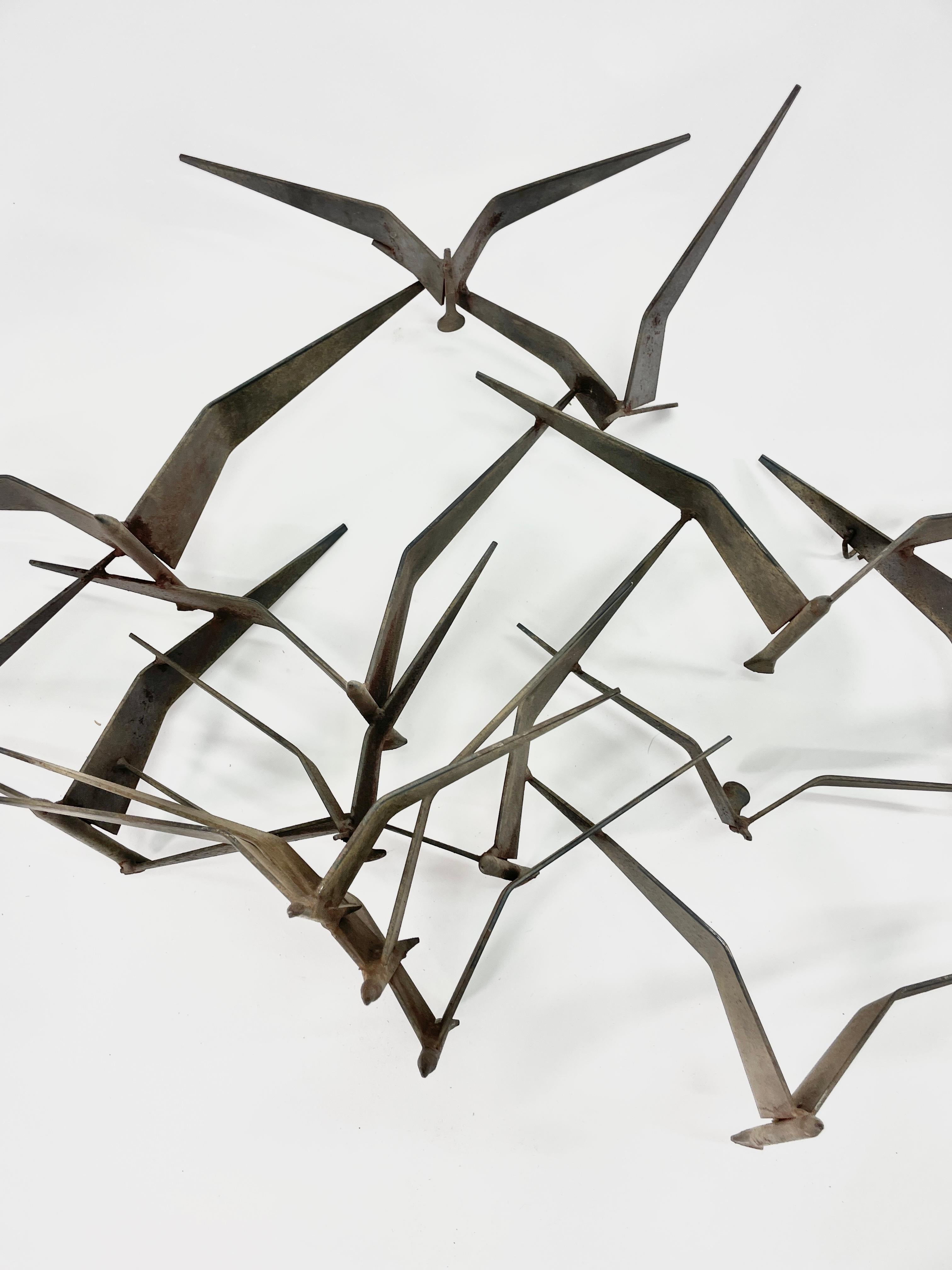  This incredible sculpture  of a flock of flying birds with wing, beak and body details. This sculpture adds depth and movement for a wall and is a great example by artist Curtis Jere. A wonderful sculptural piece by the iconic metal crafters of the