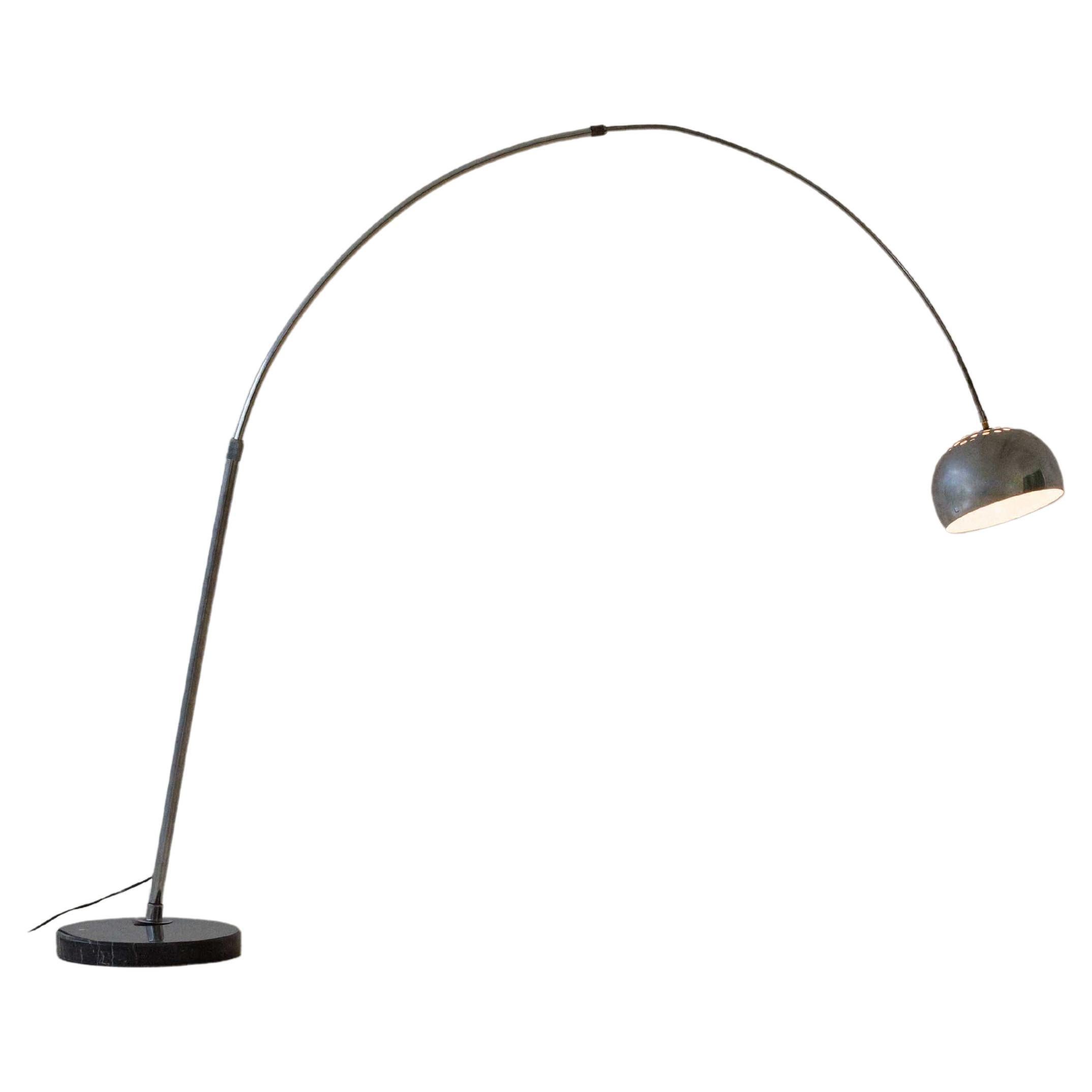 This vintage floor lamp from the 1960s has a tubular shape and curved structure like a fishing rod. The base is a marble disk, and the light source is smooth and diffused, ideal for creating a cozy mood. This unique design has a chromed steel