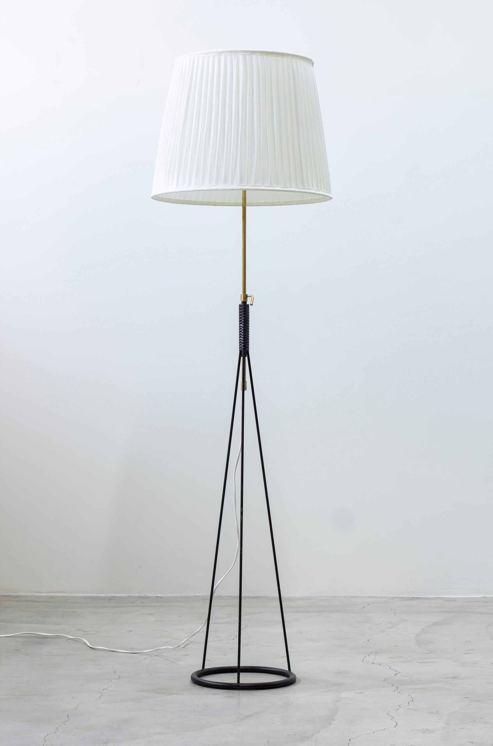 Lampadaire conçu par Eje Ahlgren. Produit en Suède par Luco dans les années 1950. Fabriqué en métal laqué noir et en laiton. Nouvel abat-jour en tissu chintz blanc cassé. Réglable en hauteur. Interrupteur en bkelite sur le support de la lampe. Très