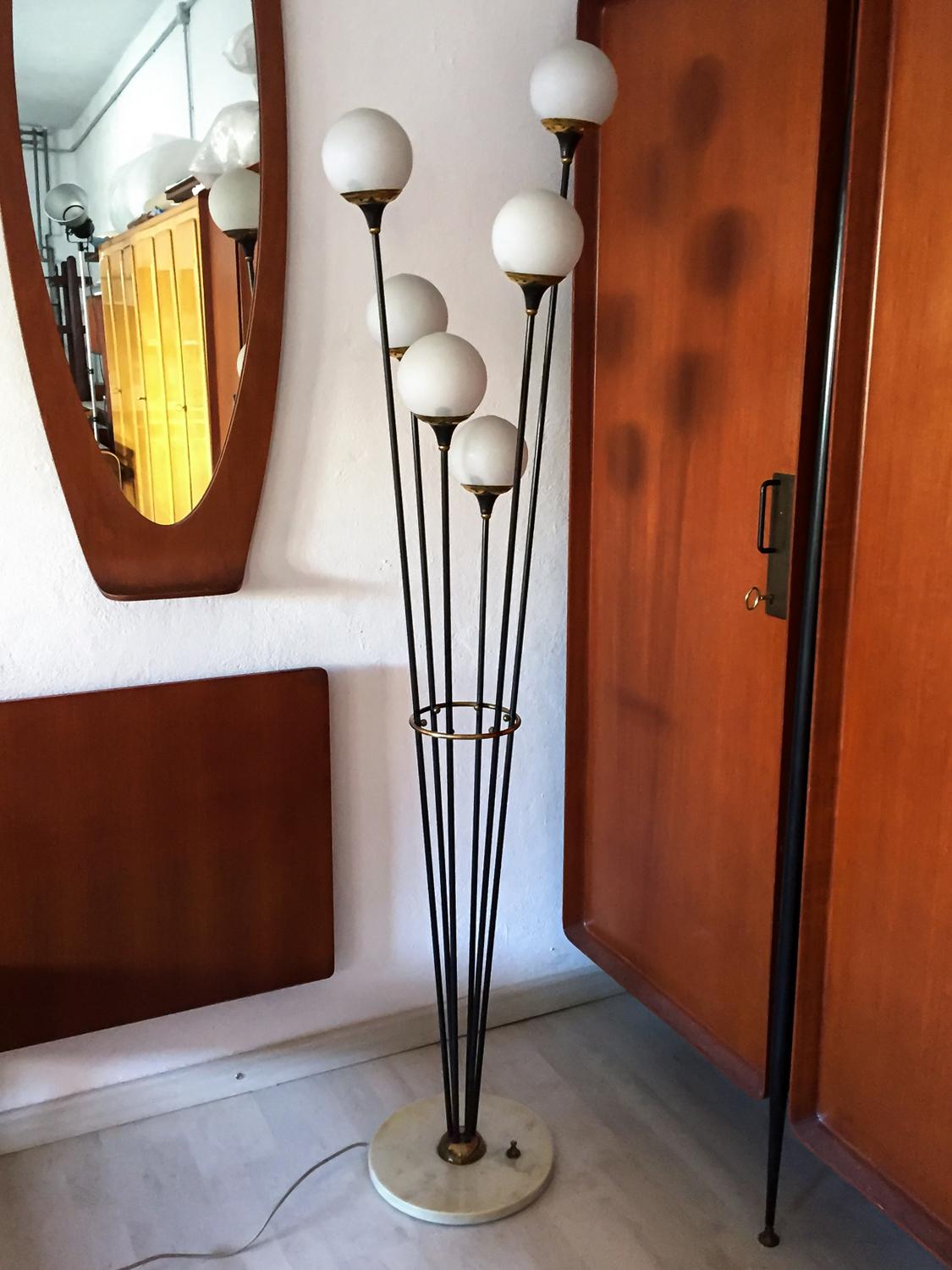 One of the most famous Stilnovo floor lamp six-lights, manufactured in Italy in the circa 1950.
Marble round base, black metal structure with six white opaline blown Murano glass balls and brass lampshades.
It's in good conditions of the period with