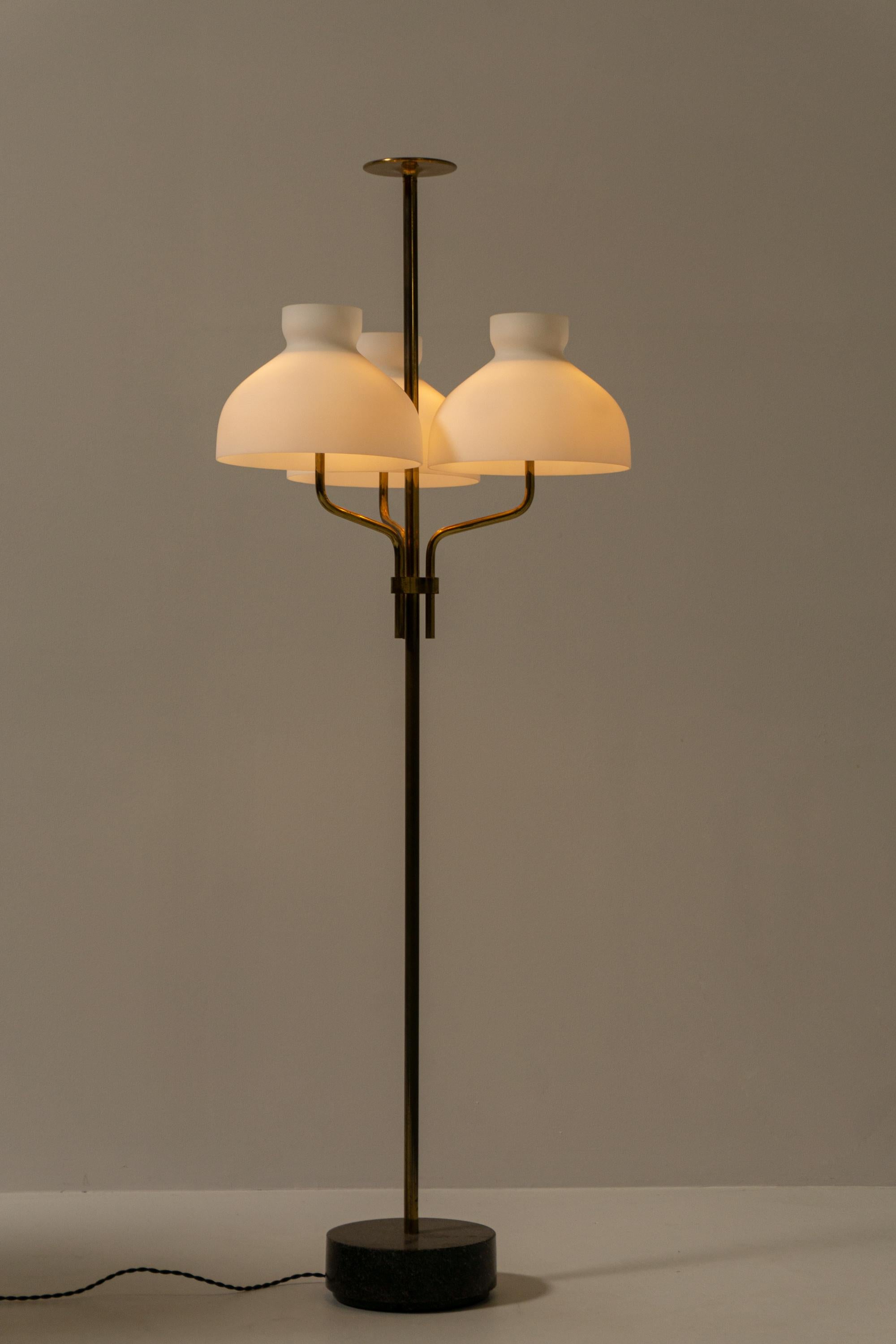 This elegant floor lamp, designed by Ignazio Gardella in 1956, consists of a brass stem held by a marble base and three glass elements for lighting. The saucer glass is mouth blown and satin finish.
The three curved lampshades give the lamp an