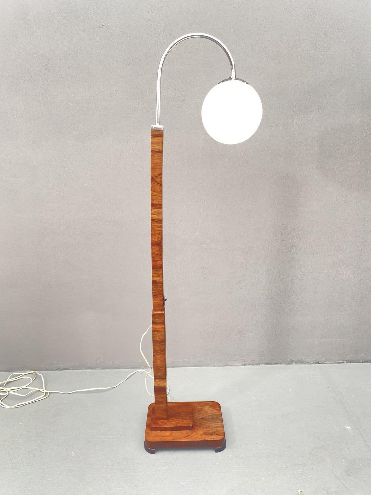 Add a touch of vintage charm to your home decor with this beautiful walnut floor lamp.

The lamp boasts an ART DECO style that is sure to catch the eye of any visitor. Made in Czechoslovakia in 1930, this lamp is a true collectible item that adds