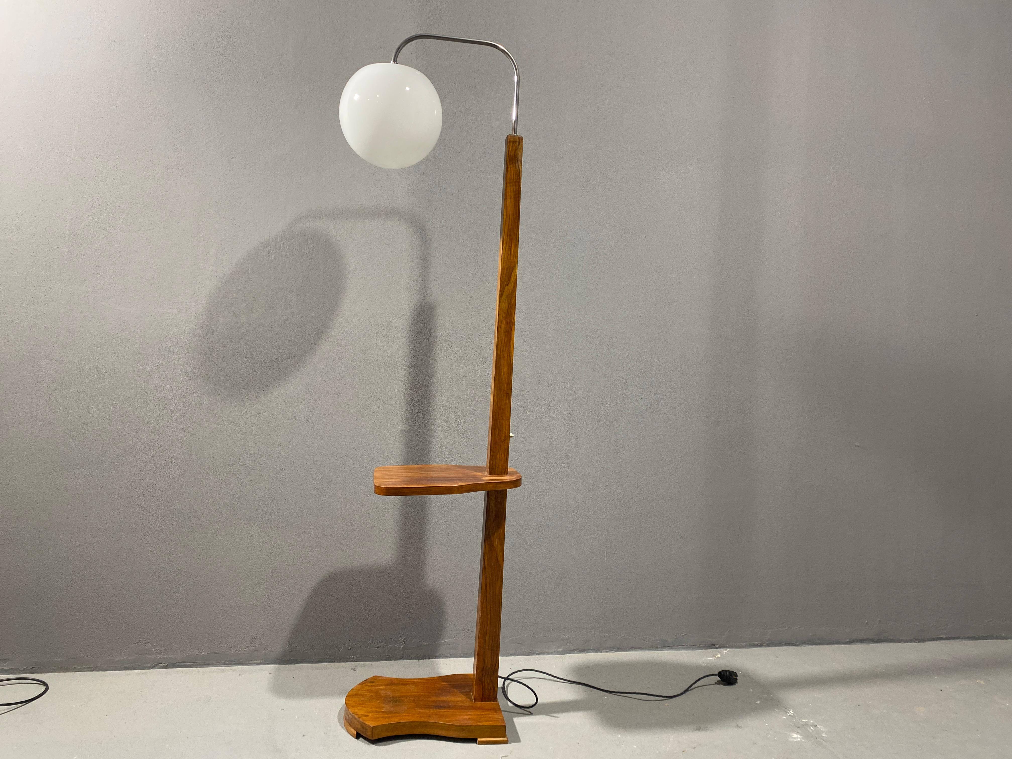 Add a touch of vintage charm to your home decor with this beautiful walnut floor lamp.

The lamp boasts an ART DECO style that is sure to catch the eye of any visitor. Made in Czechoslovakia in 1930, this lamp is a true collectible item that adds