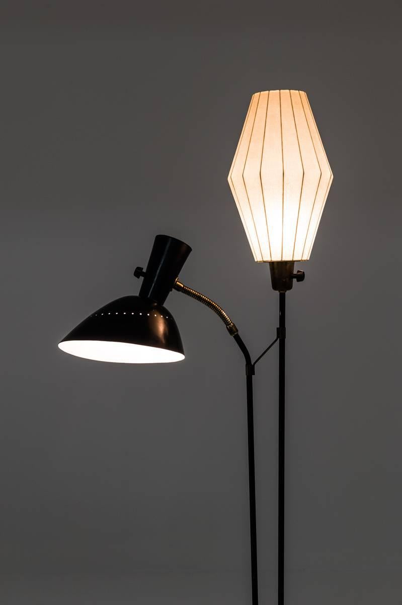 Beautiful floor lamp by Hans Bergström for Swedish manufacturer Ateljé Lyktan. 
This floor lamp consists of two light sources, one hidden behind a spray plastic shade and one perforated metal shade held by an adjustable arm. 

Condition: Very