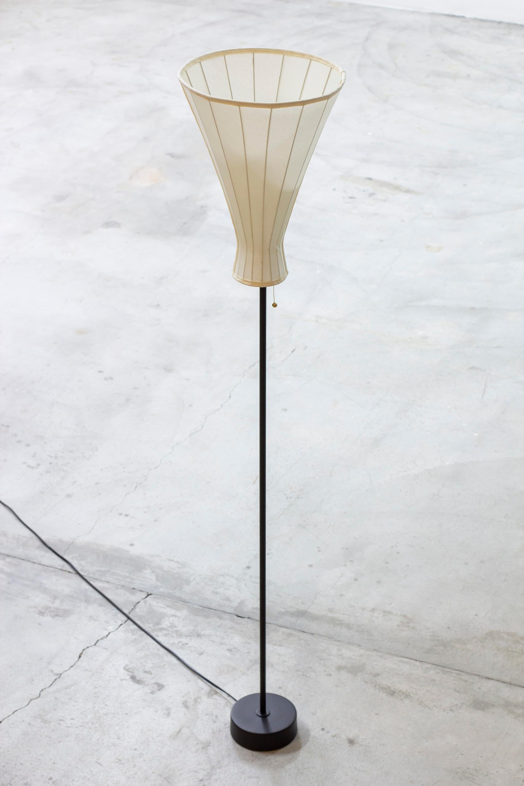 Floor lamp attributed to Hans Bergström. Produced by Ateljé Lyktan in Sweden during the 1950s. Made from black lacquered brass with brass details. Uplight shade has been reupholstered with new chintz fabric in a slight off white color. Chord light