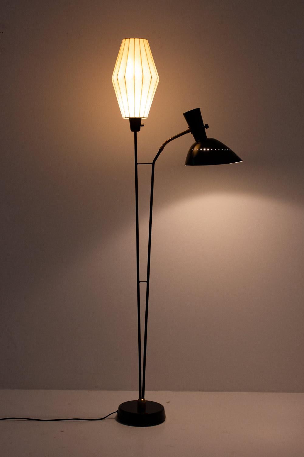 Beautiful floor lamp attributed to Hans Bergström for Swedish manufacturer Ateljé Lyktan.
This floor lamp consists of two-light sources, one hidden behind a spray plastic shade and one perforated metal shade held by an adjustable arm.