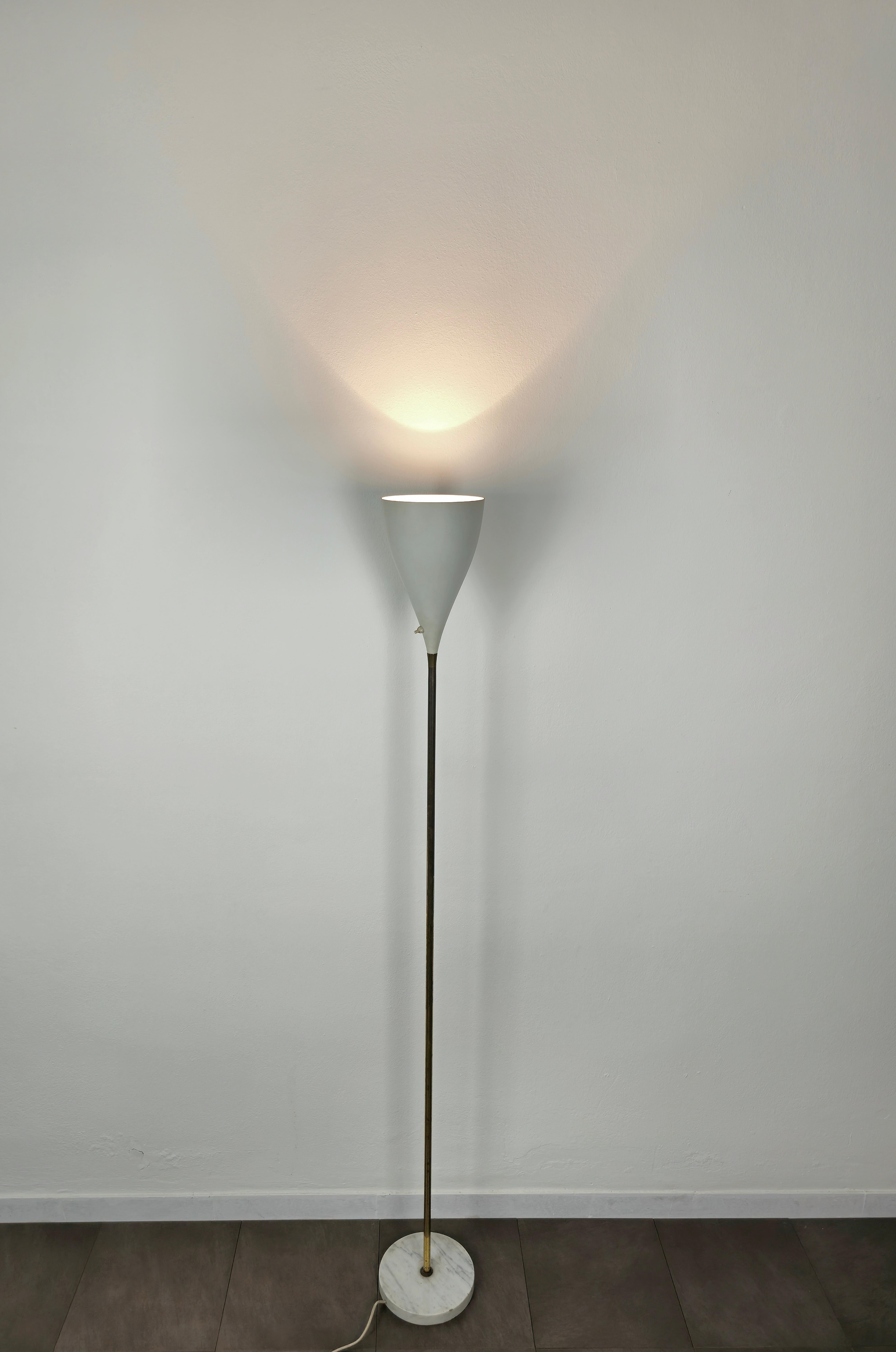 Rare et élégant lampadaire avec 1 lumière E27 produit en Italie dans les années 1950, attribué à Stilnovo.
Le lampadaire a été réalisé avec une base circulaire en marbre blanc où se trouve une longue tige en laiton avec un diffuseur de forme conique