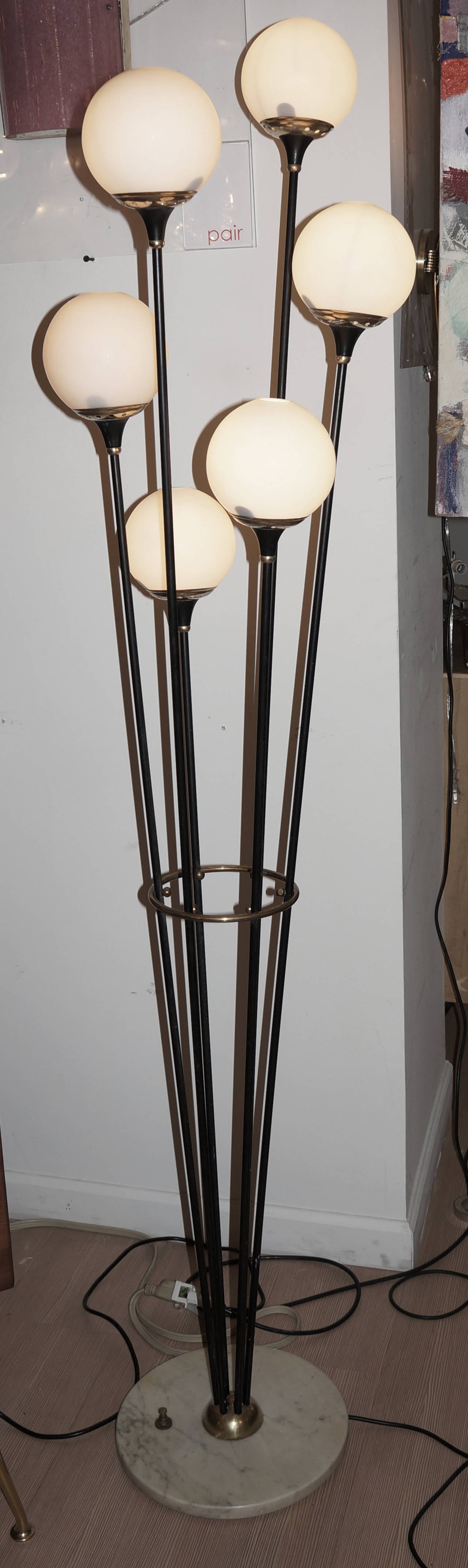 Sculptural floor lamp featuring six long stems with frosted glass globes departing from a gray marble base. This lamp is commonly attributed to Stilnovo. Stilnovo after enjoying success from the 1950s to the 1970s, was less effective in the
