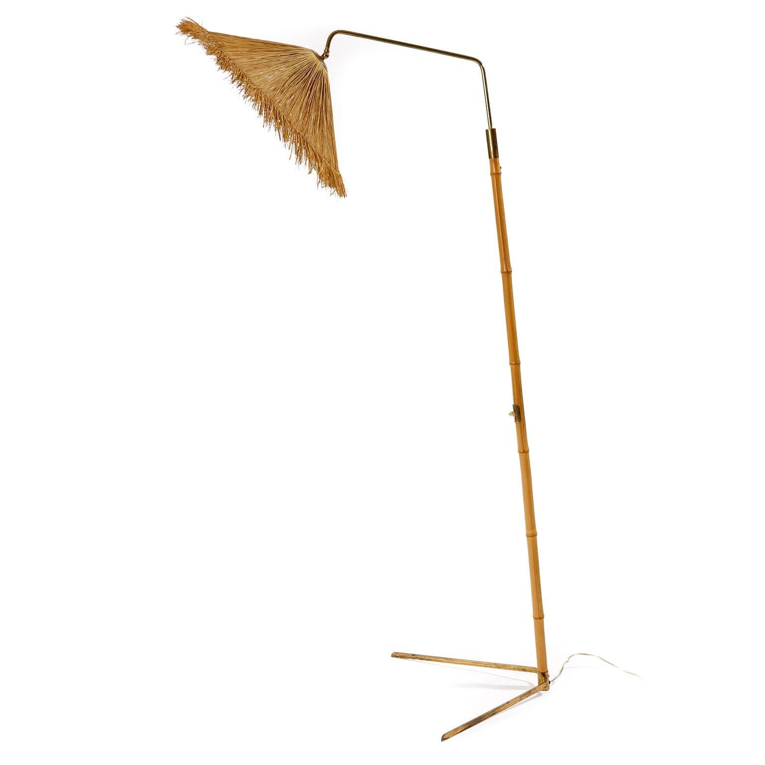 A floor lamp manufactured in Austria in midcentury, circa 1960 (late 1950s or early 1960s).
It is made of a nice mixture of materials and colors: a bamboo rod, naturally aged and patinated brass, and a lamp shade made of straw.
The lamp shade is