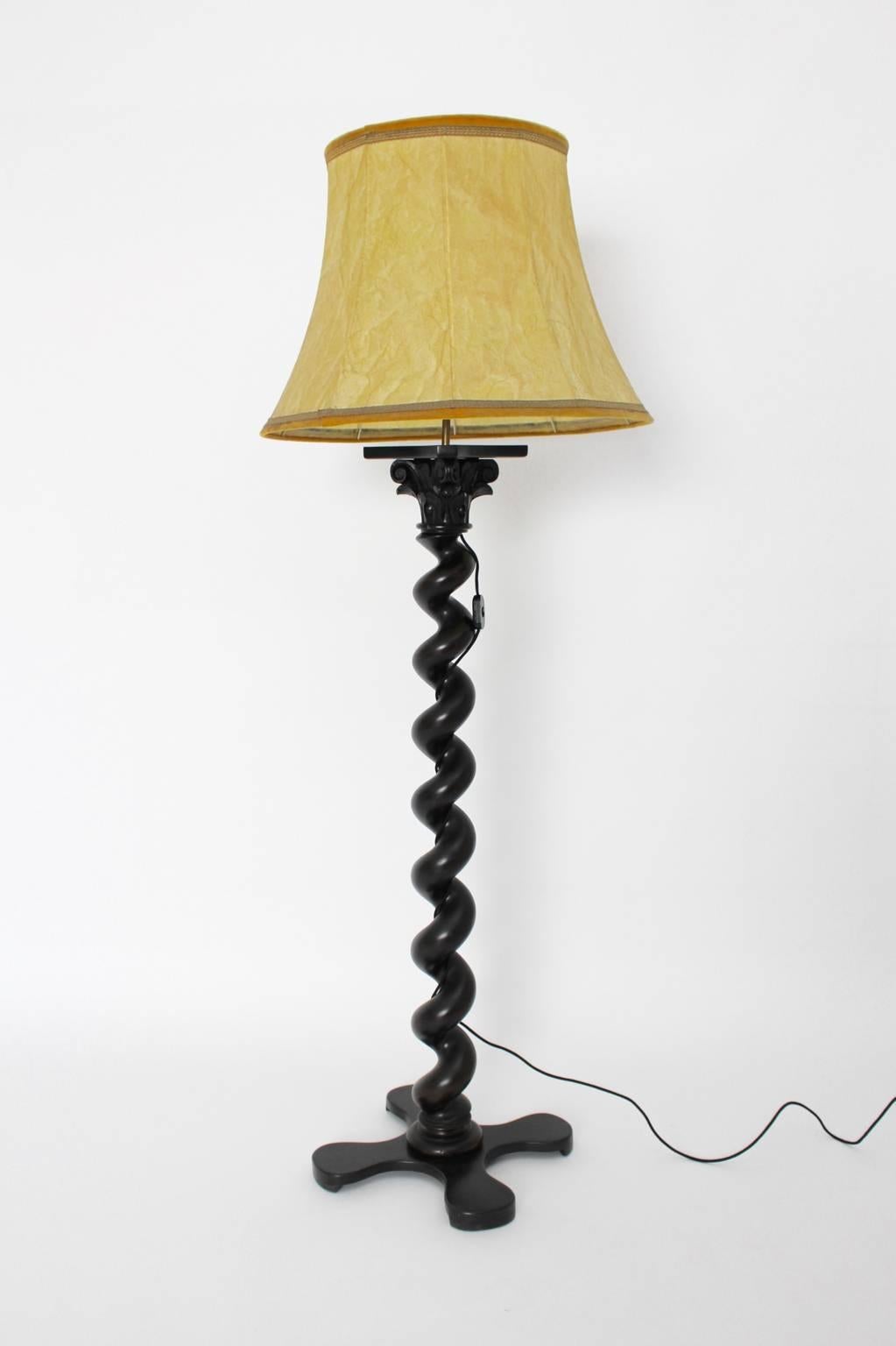 Baroque style vintage turned beechwood stem of the floor lamp is a genuine part from a baroque cabinet.
The floor lamp was composed in the 1950s.
The floor lamp has a light lamp shade and features two E 27 sockets with an on/off switch.
The vintage