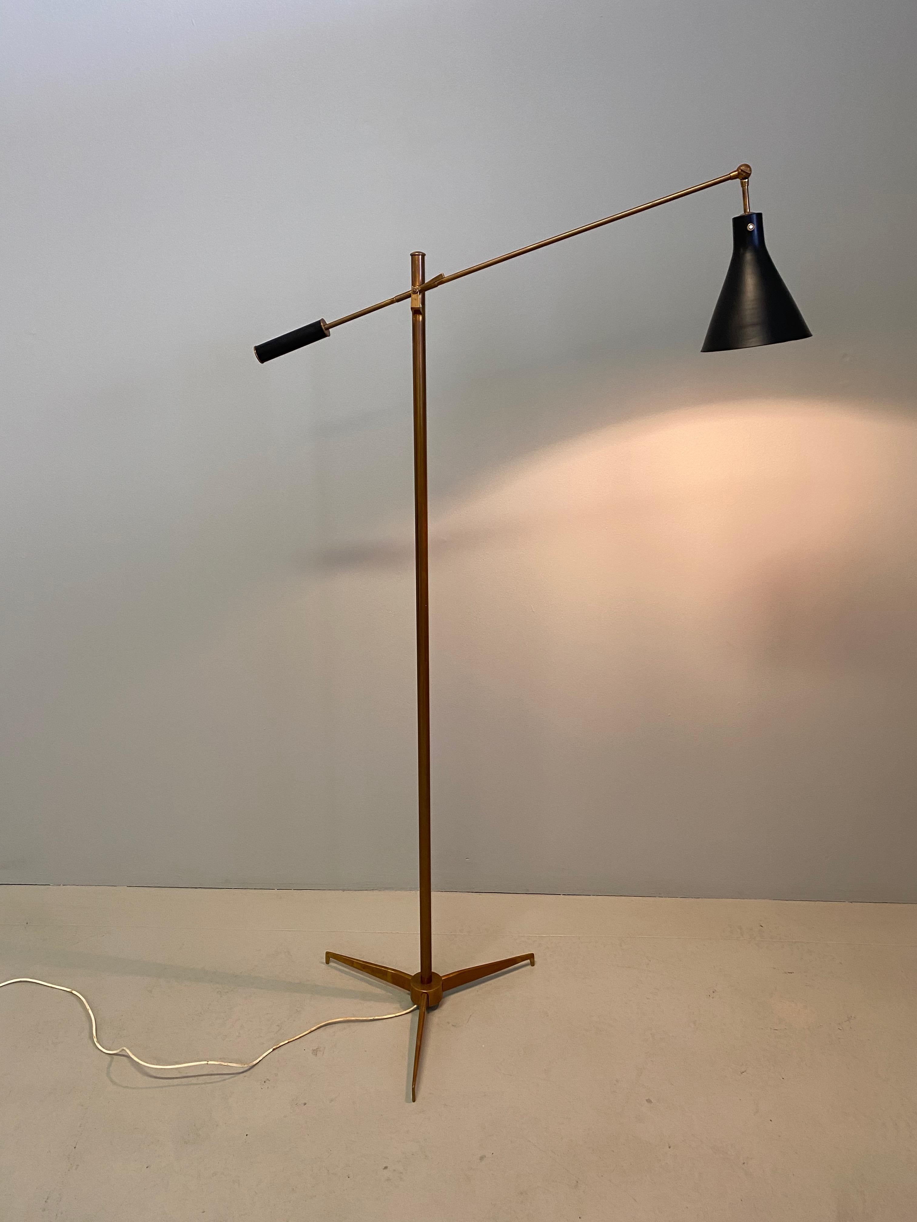 Brass floor lamp with painted aluminum shade by Angelo Lelli for Arredoluce. Designed in Italy, circa 1950s. Shade and arm can be adjusted to various heights and positions with brass key. On/off switch on shade.