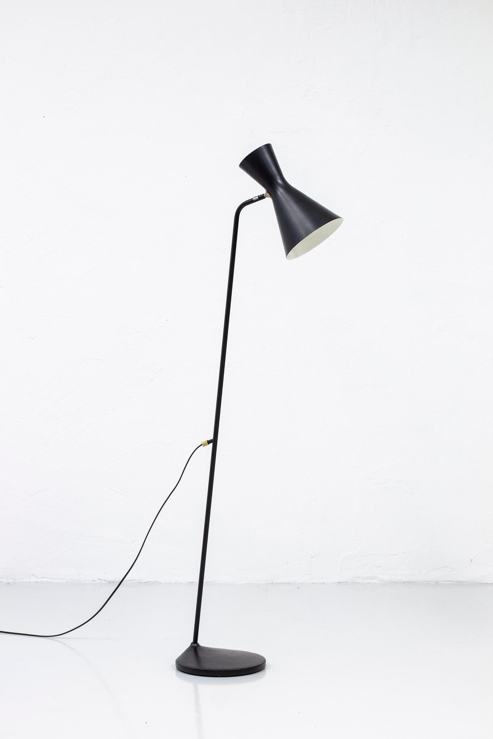 Floor lamp produced by ASEA belysning in Sweden. Made during the 1950s. Black lacquered cast iron, metal and aluminum with chrome and brass details. Shade adjustable in angle. Light switch on the chord. Good vintage condition with wear and patina