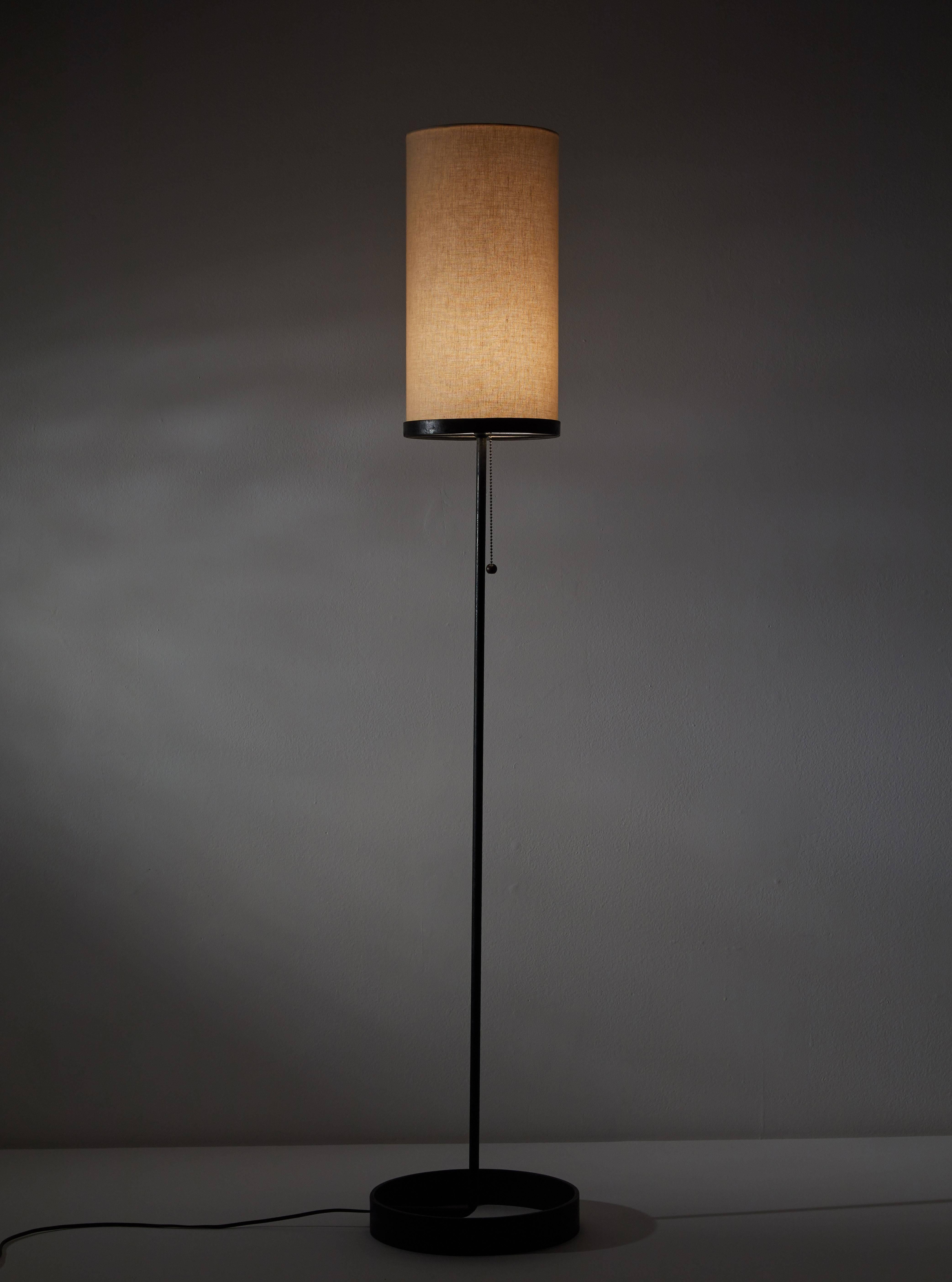 Floor lamp by Ben Siebel. Designed and manufactured in the USA, circa 1950s. Custom fabricated linen shade, enameled metal base and pull switch. Original cord. 
Takes one E26 75w maximum bulb. SHADE INCLUDED